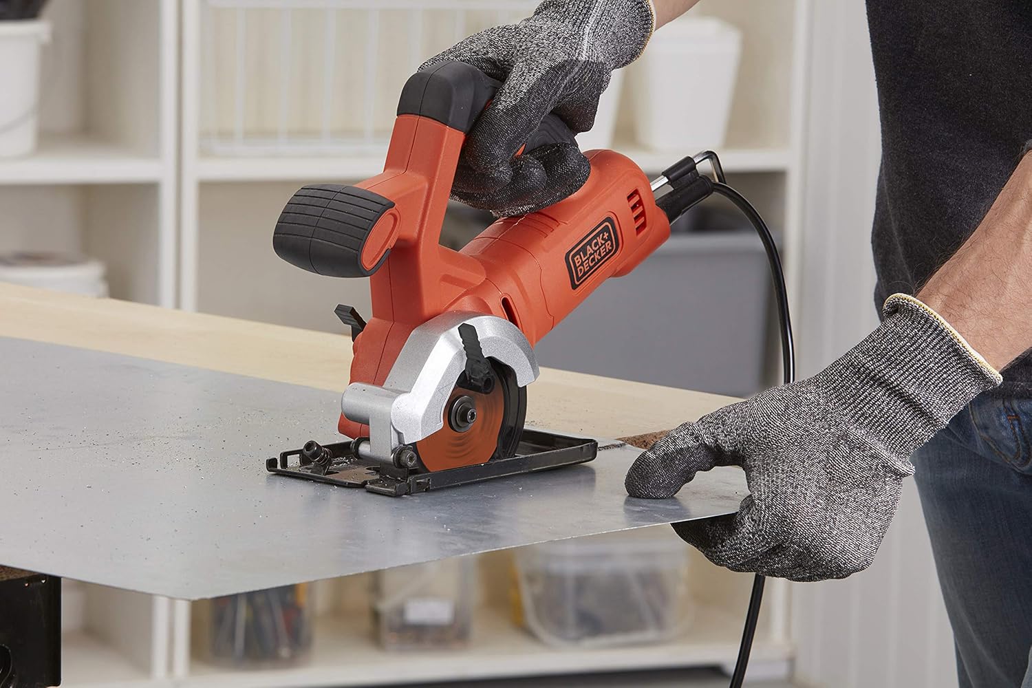 User cutting a thin sheet of metal with the BLACK+DECKER BES510-QS Mini Circular Saw
