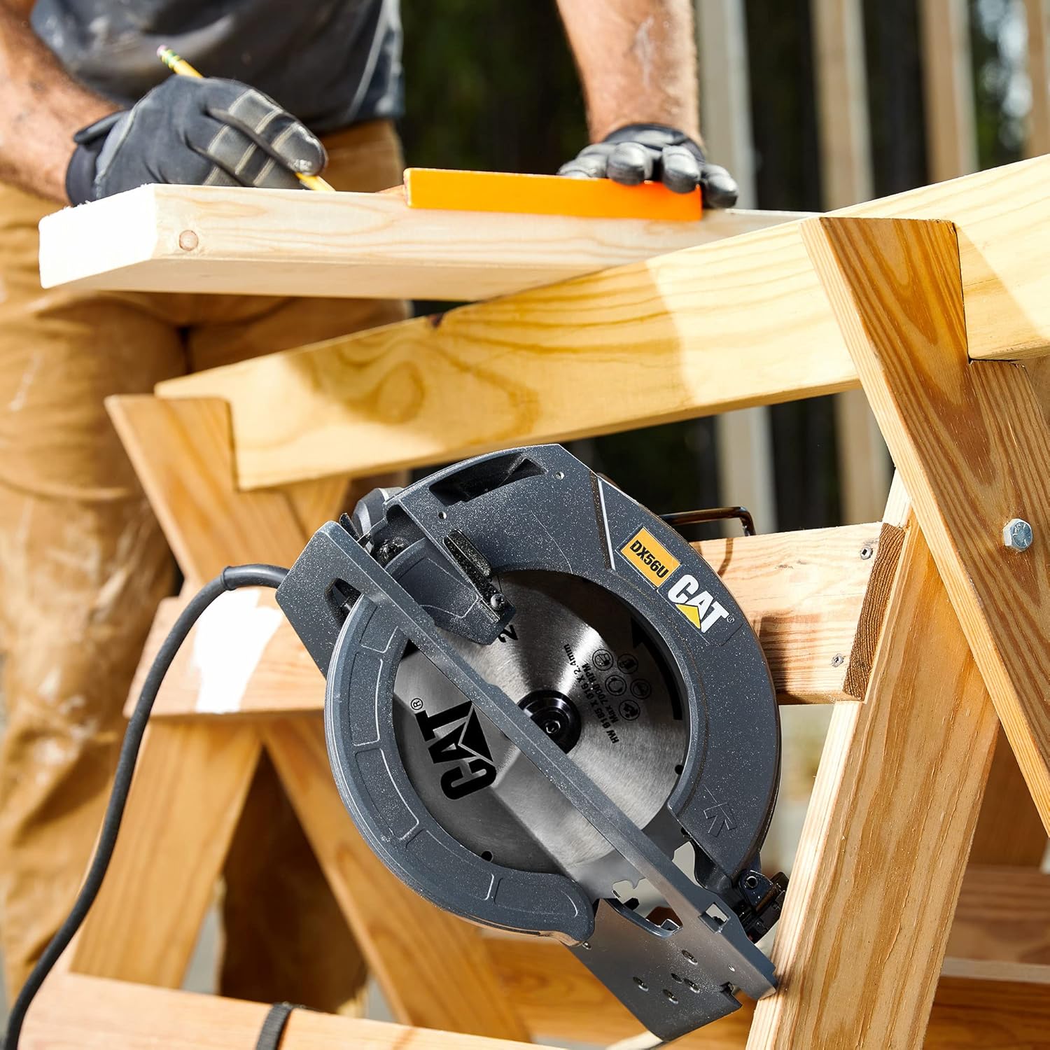 CAT DX56U Circular Saw on a workbench with a user marking wood