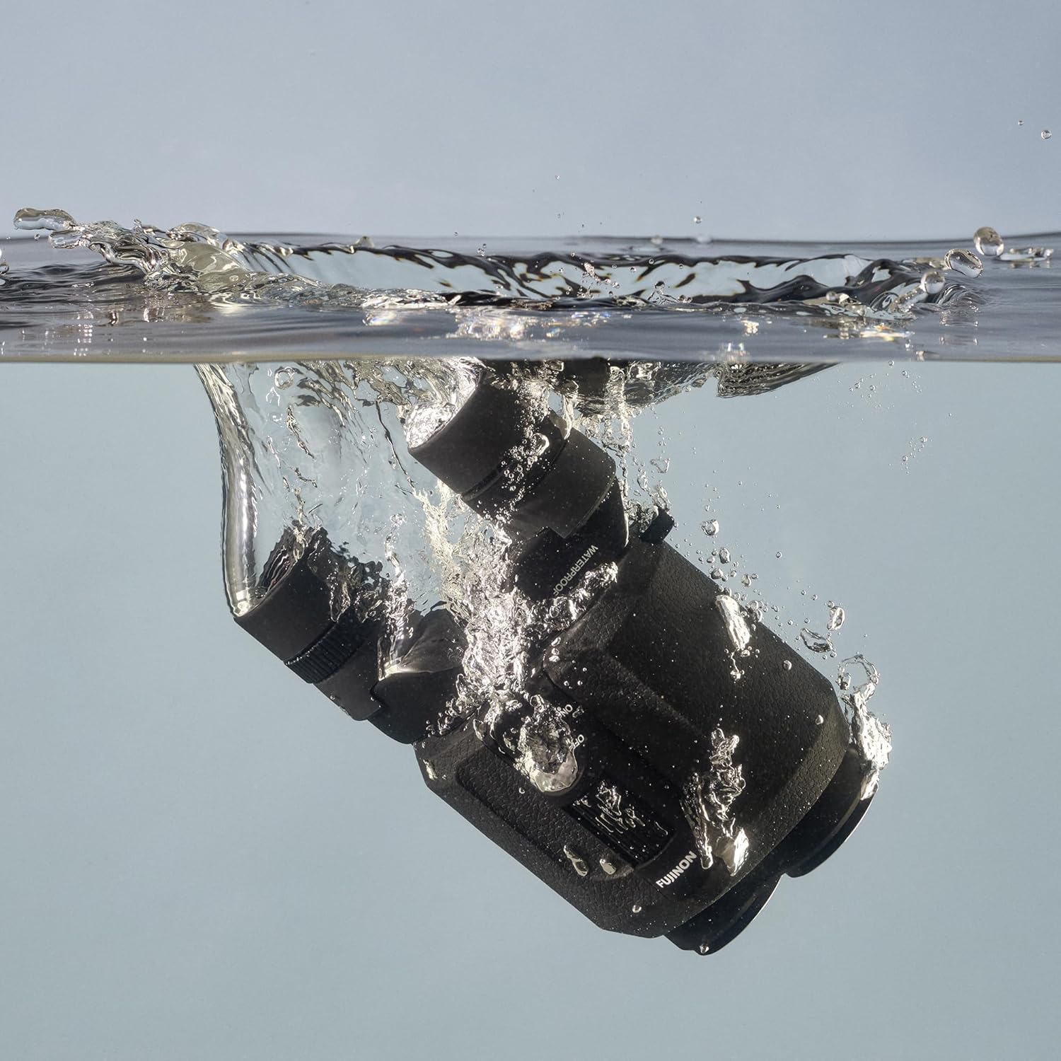 Hand inserting a CR2 battery into the binocular