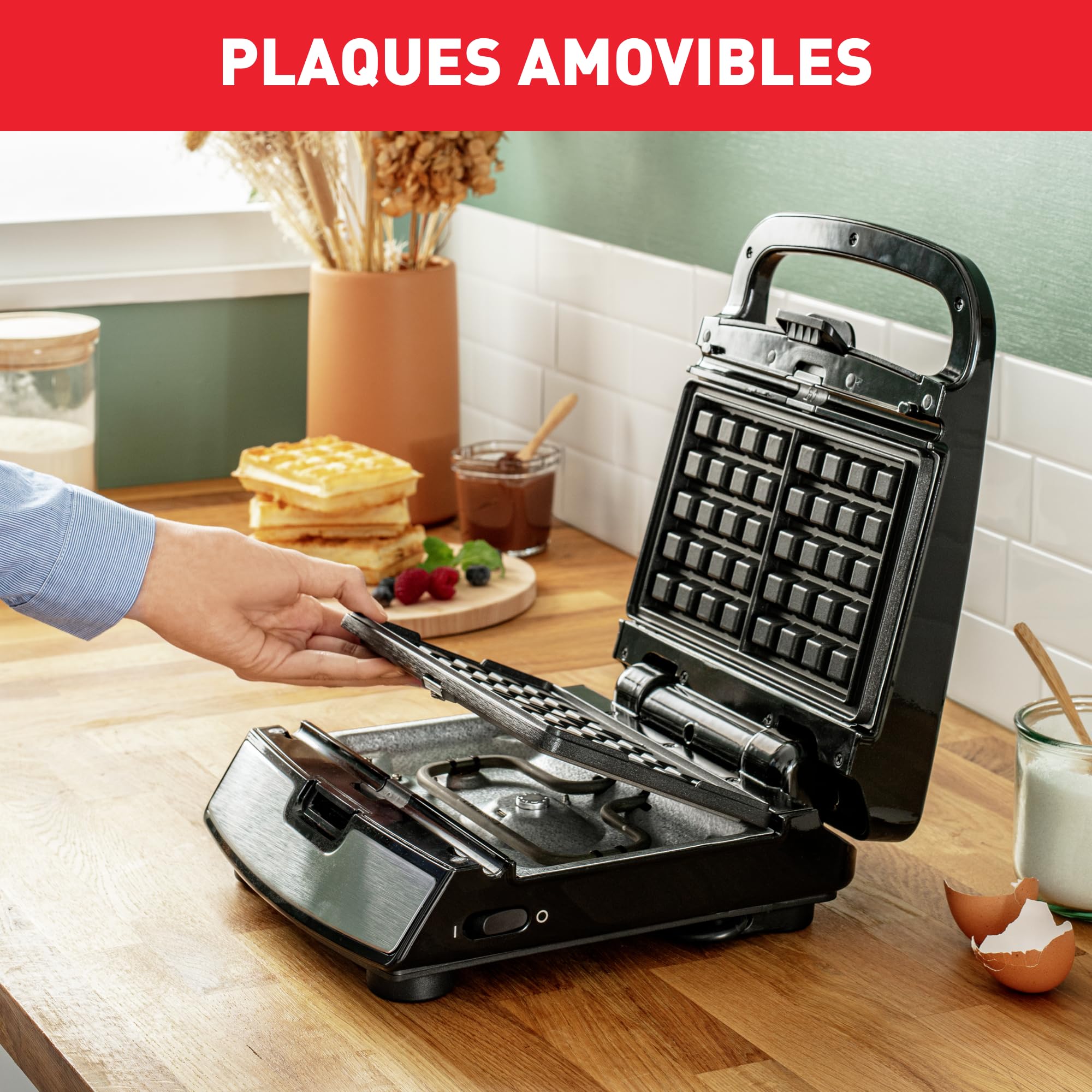 A hand demonstrating how to remove an interchangeable cooking plate from the Tefal Snack Collection SW854D.