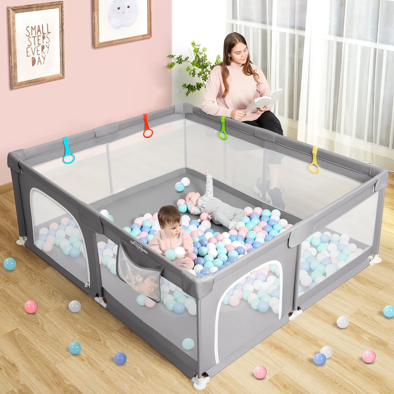Two babies playing safely inside the OTTOLIVES playpen with colorful balls