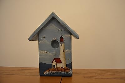 Amish Wares Wood Birdhouse with Lighthouse Surrounded by Water, Rocks, Sailboats, and Seagulls. Measurements are 1 X 4 1/4 X 5 1/2