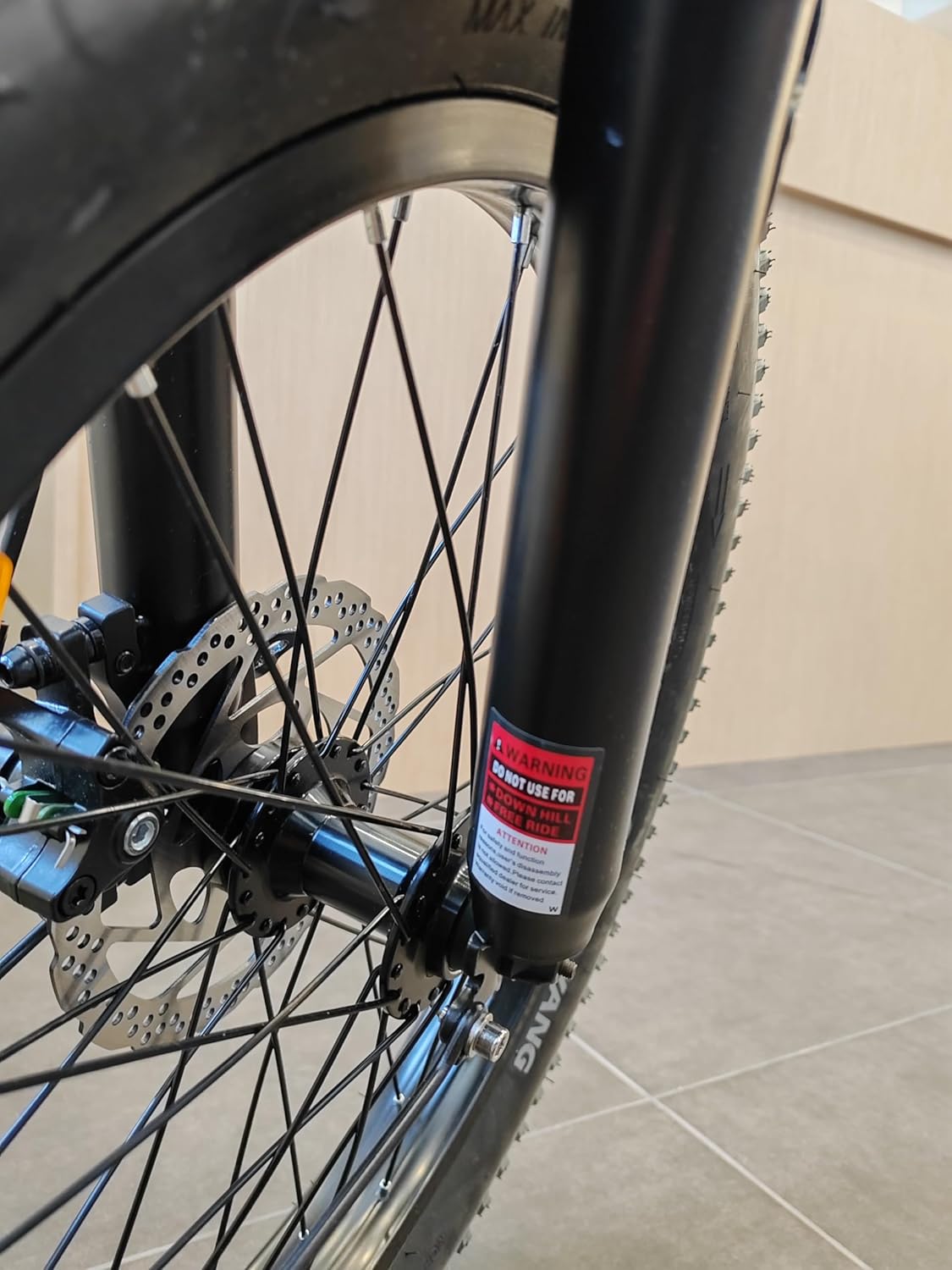 Close-up of Windgoo E-bike front fork with a warning label