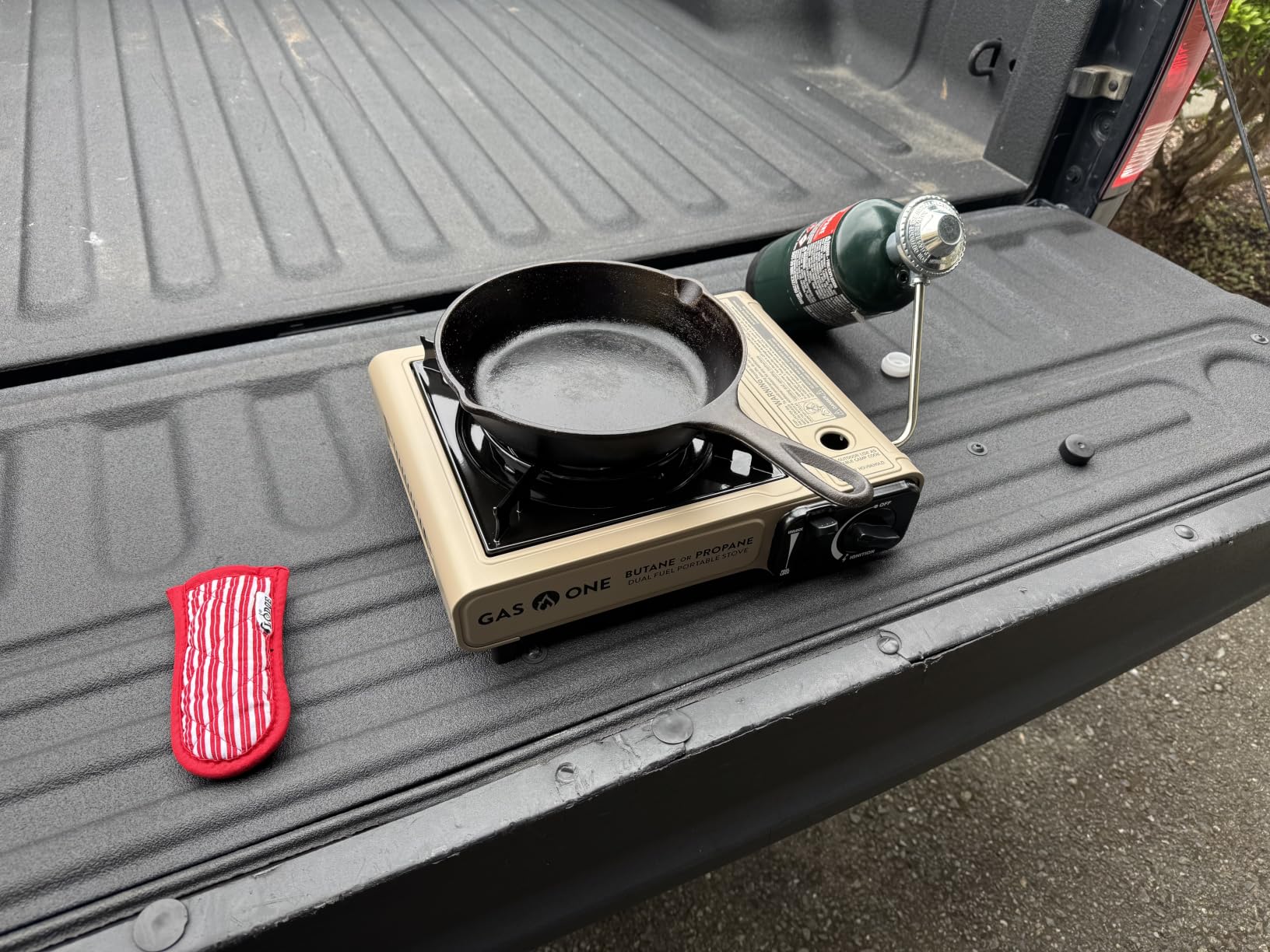 Best camping stoves lined up on a campsite with mountain backdrop