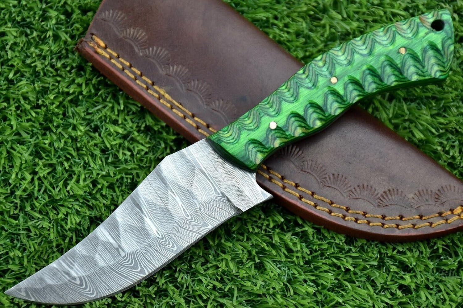 Damascus steel blade skinning knife with Leather sheath, 4.25 inches long Hand forged clip point blade with 3.75 inch cutting edge, Green wood scale Jigged with sturls, Includes Leather sheath