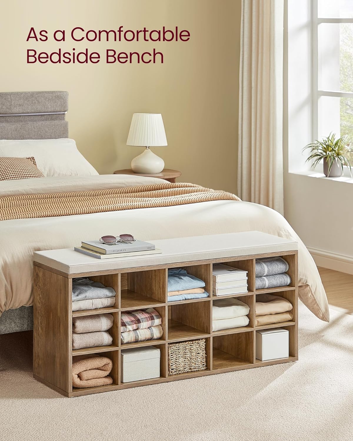 VASAGLE CUSTOS Shoe Bench used as a comfortable bedside bench with items stored in cubbies.