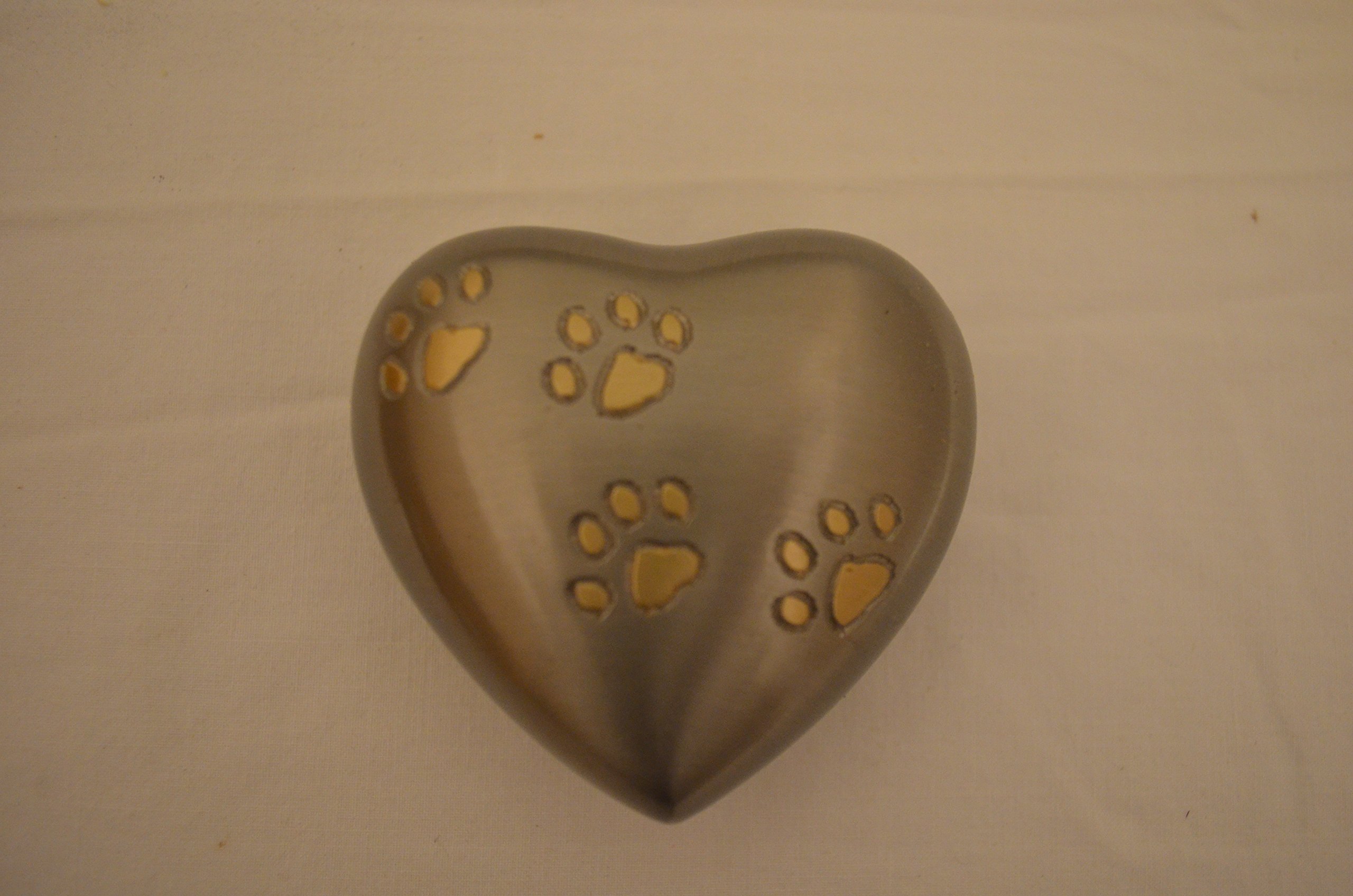 Small Silver Brass Heart Shaped Keepsake Pet Urn with Paw Print Design on Metal Brass with Size of 3.5 Inches. Some Products May Have Minor Scratches
