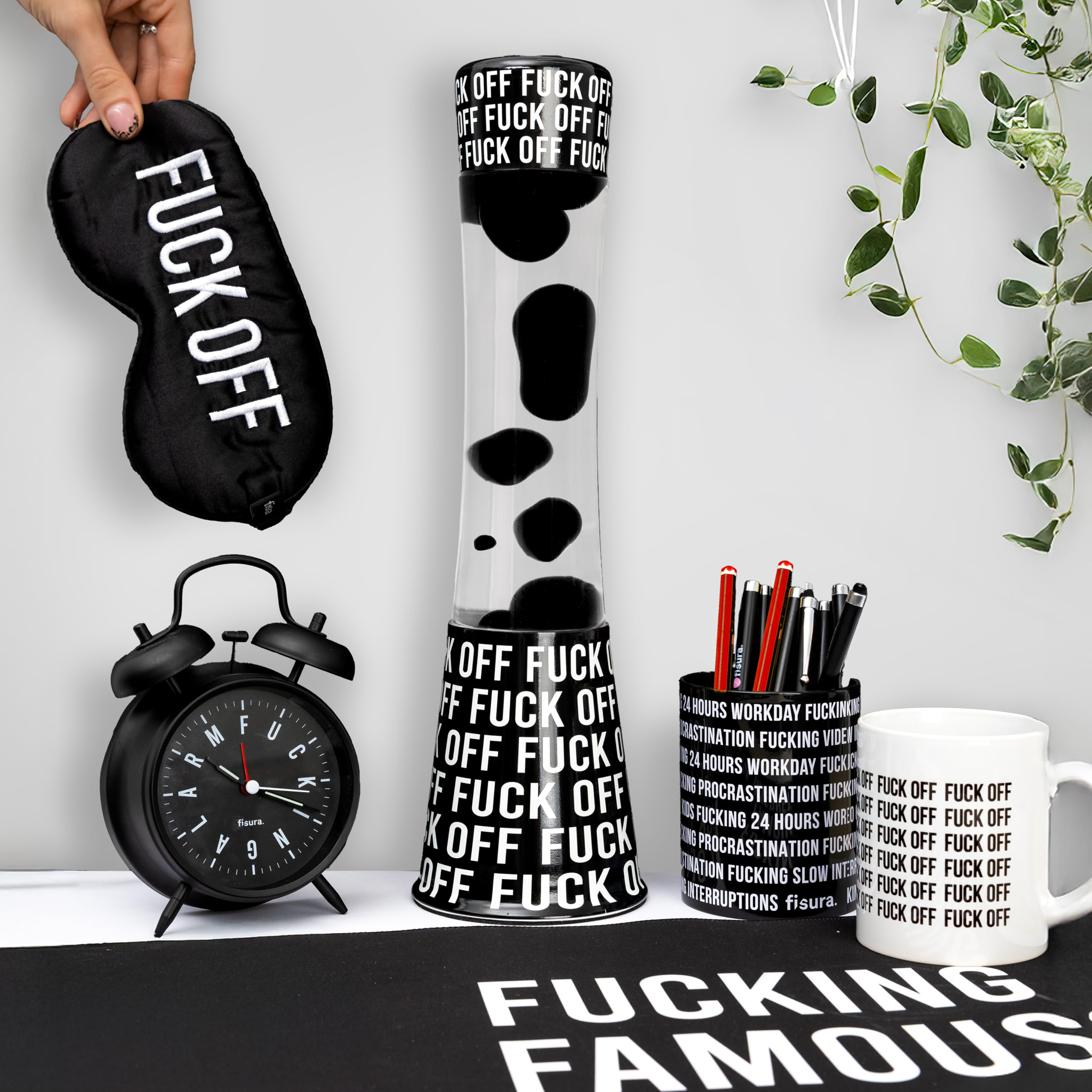 Fisura - Lampa lawa "f*ck off". Czarna podstawa z napisem, przezroczysty płyn i czarna lawa. Relaksujący efekt. Z zapasową żarówką. 11 cm x 11 cm x 39,5 cm.