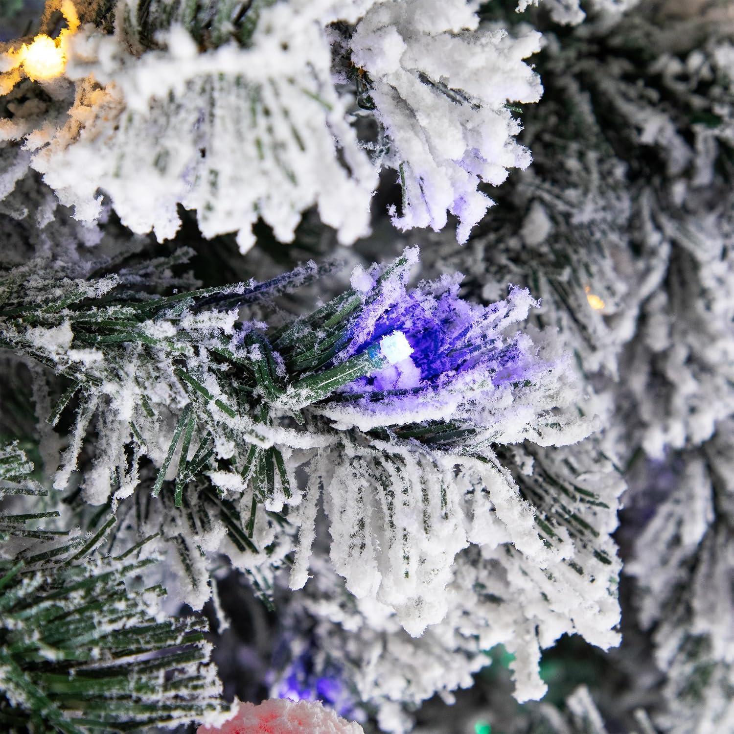 A segment of a flocked branch showing the green needles and a blue mini LED light.