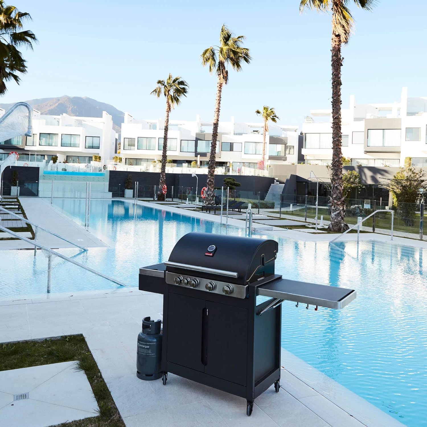 Barbecook Stella 4311 Gas Barbecue set up next to a swimming pool, ready for use.