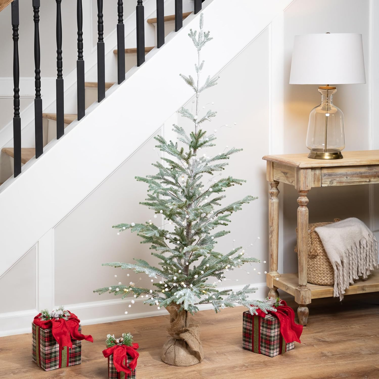Northlight LED Pom Pom Garland draped on a small Christmas tree in a home setting