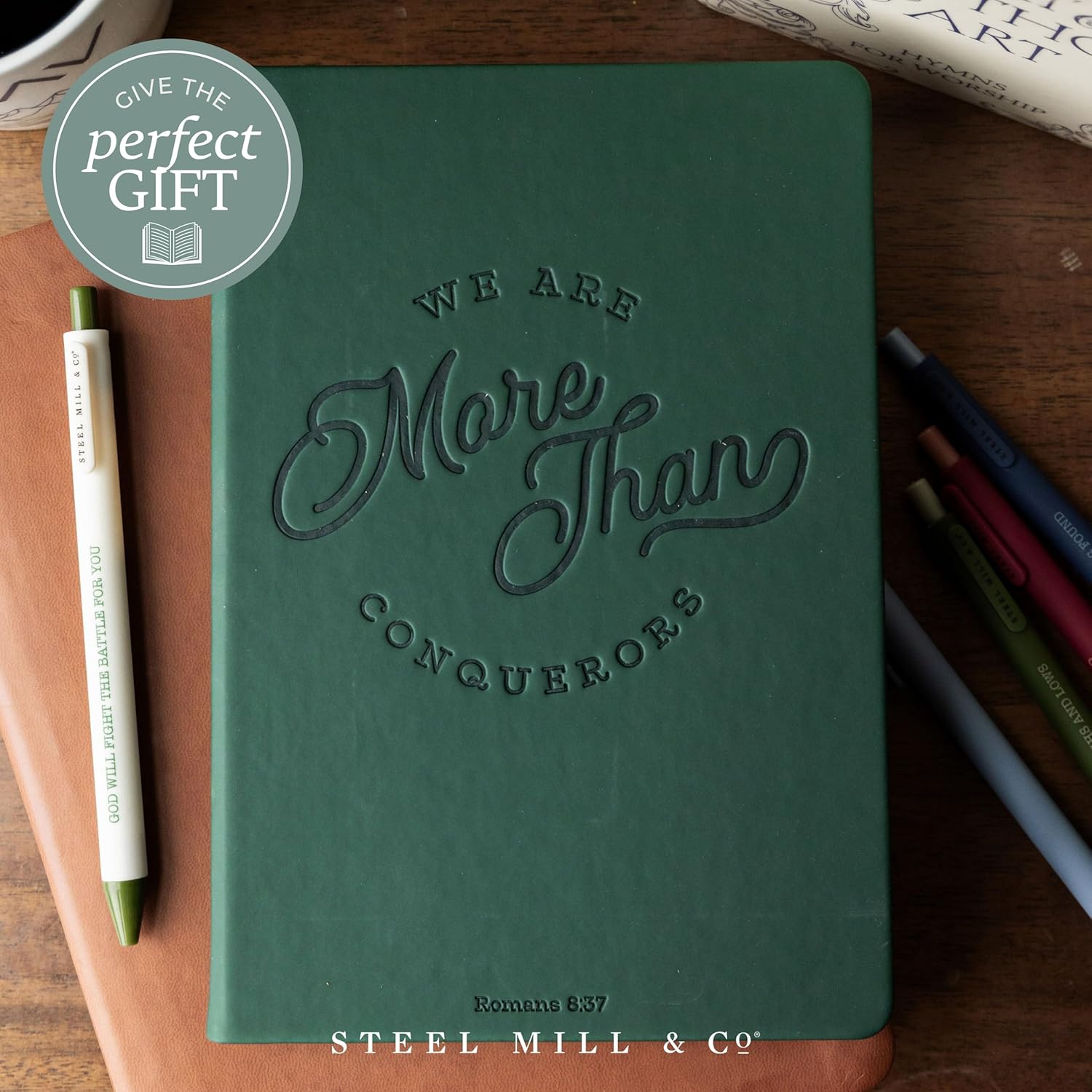 Steel Mill & Co Faux Leather Journal, 8.5” x 6” Scripture Quote Notebook with 160 Lined Pages, Book-Bound, Dark Green Leatherette Writing Journal with Debossed Cover and Ribbon Bookmark for Women & Men (More than Conquerors)