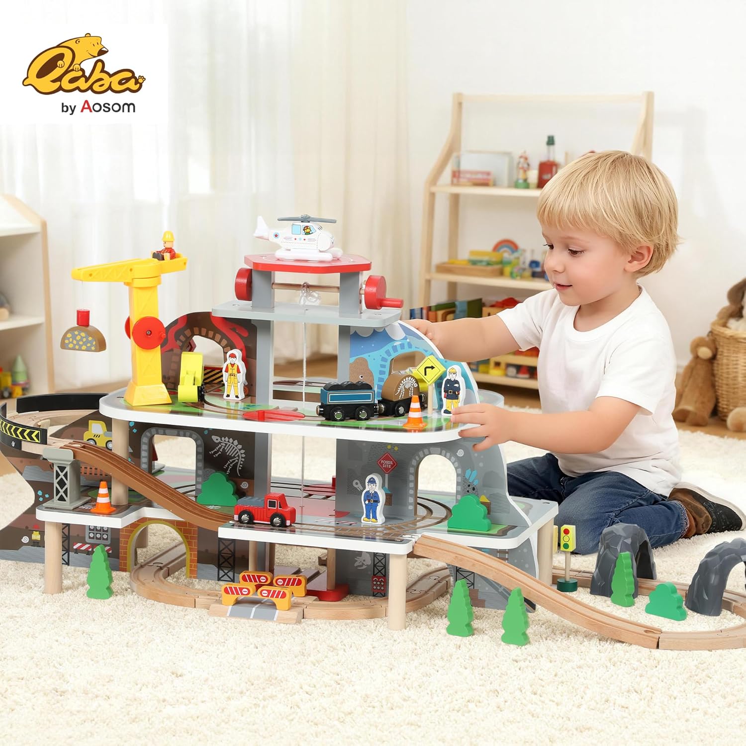 A child playing with the fully assembled Qaba Wooden Train Set, showing the multi-level structure, tracks, crane, and helicopter pad.