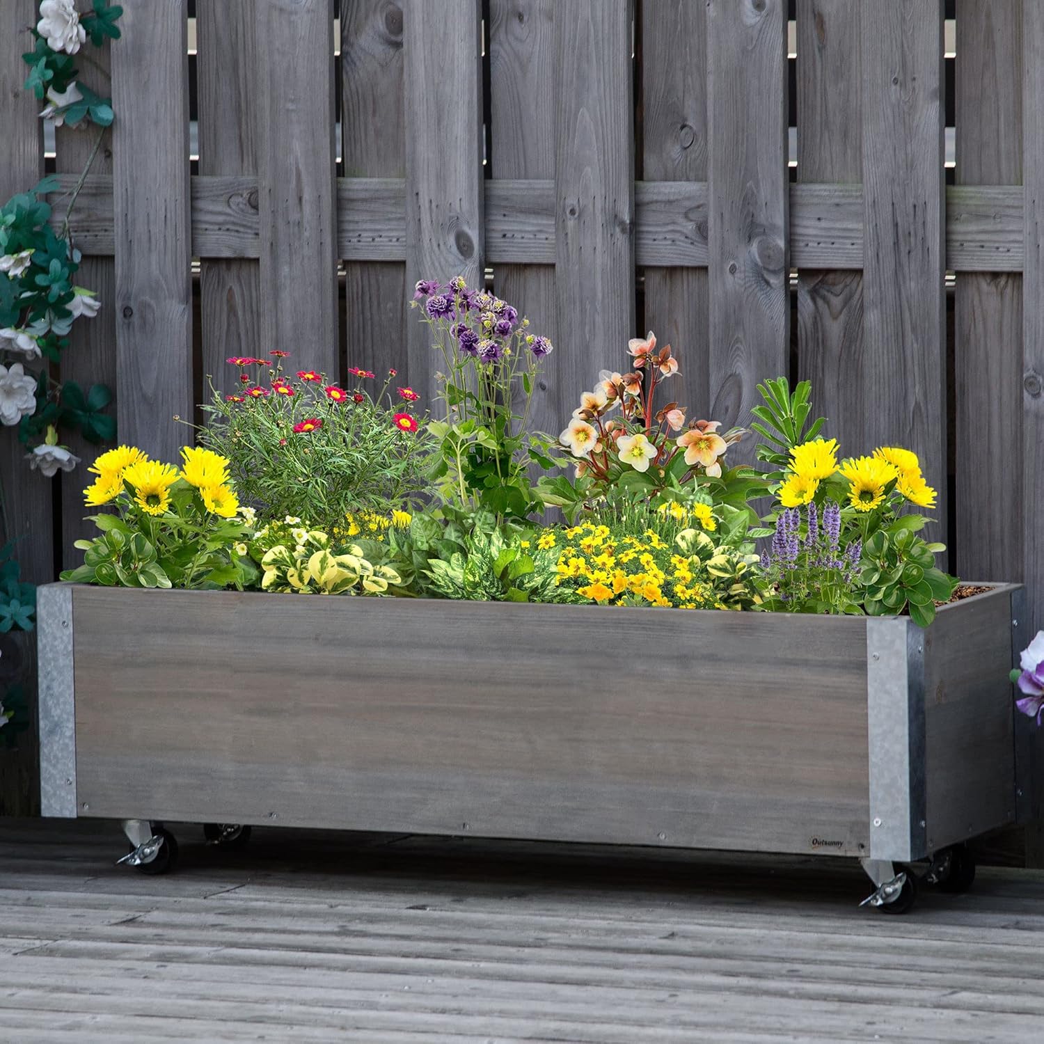 Outsunny Rolling Planter filled with various colorful flowers on a wooden deck.