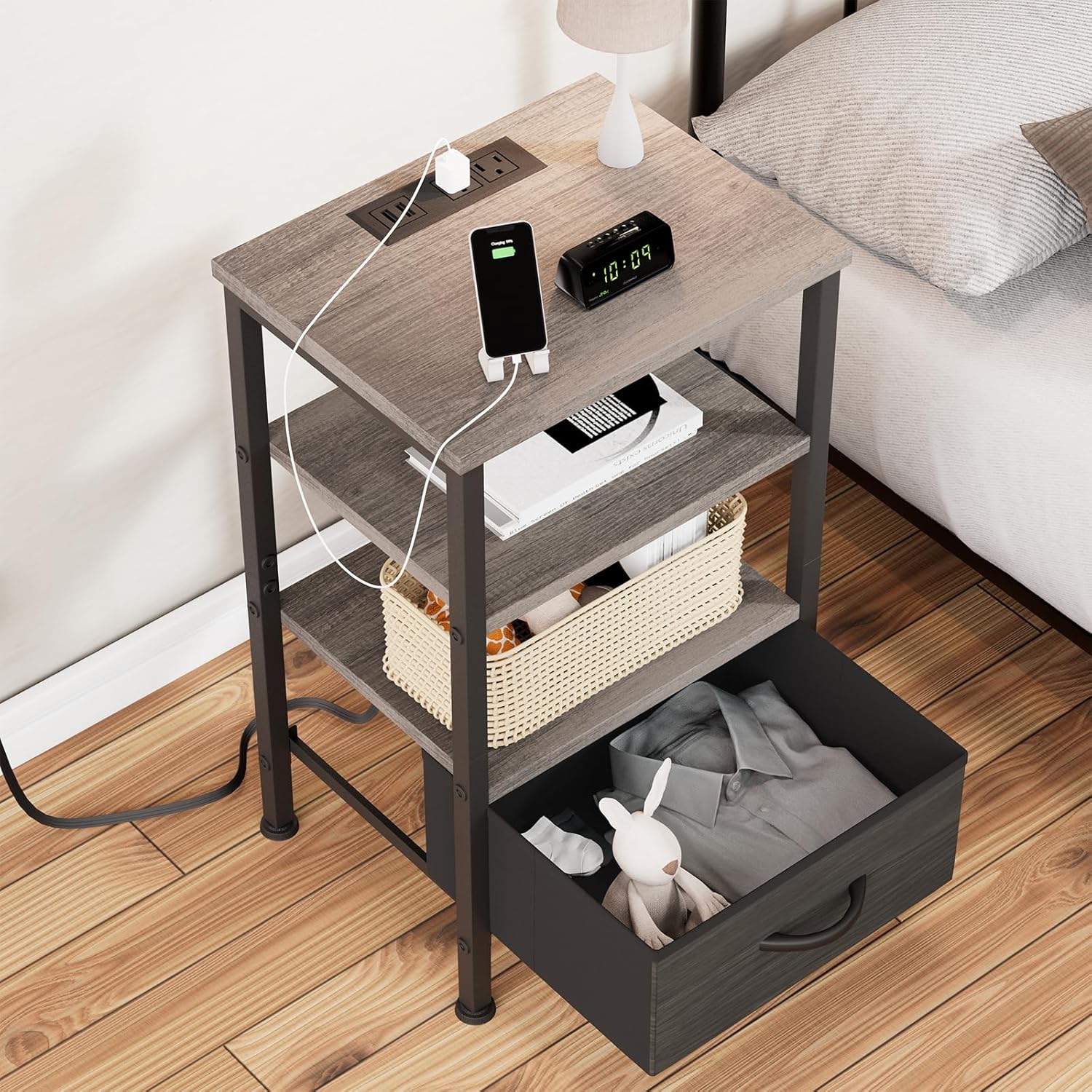 Top-down view of a Fixwal nightstand next to a bed, showing the charging station in use and the fabric drawer pulled out.