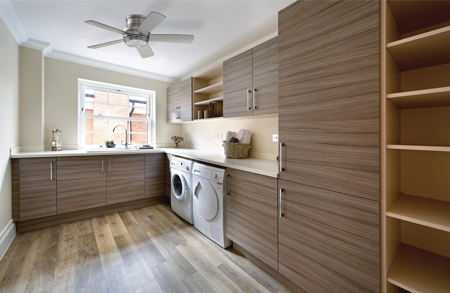 Craftmade Tempo 44-inch ceiling fan installed in a modern laundry room with wood cabinets and light countertops, demonstrating its flush mount design and suitability for various indoor spaces.