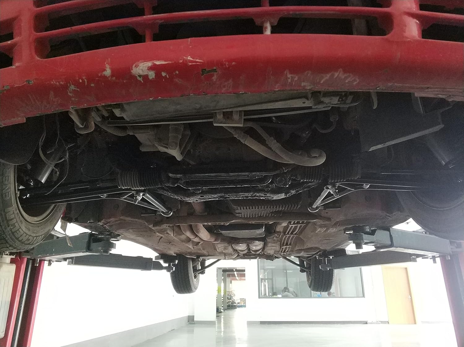 Undercarriage view of a car on a lift, showing the front suspension area