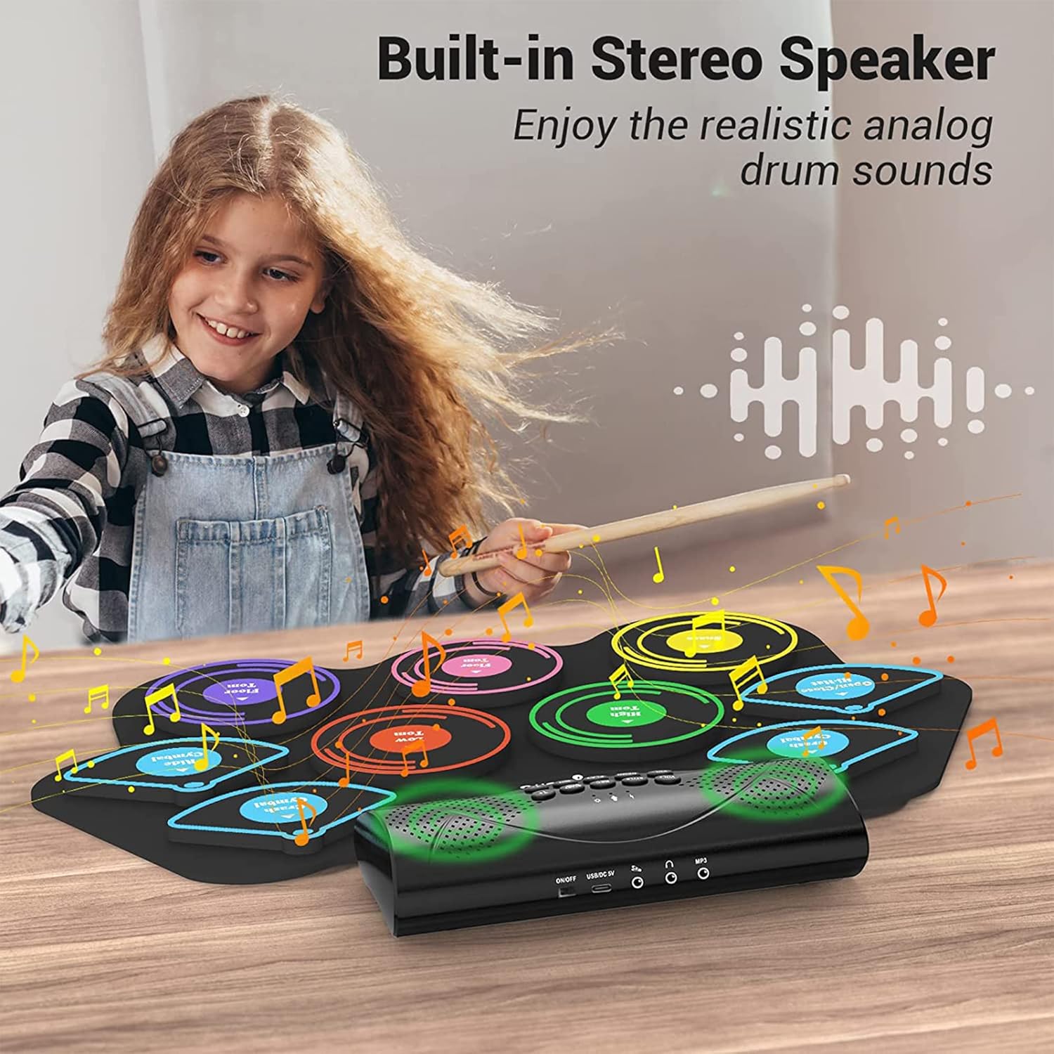 Child playing the electronic drum set with built-in stereo speakers