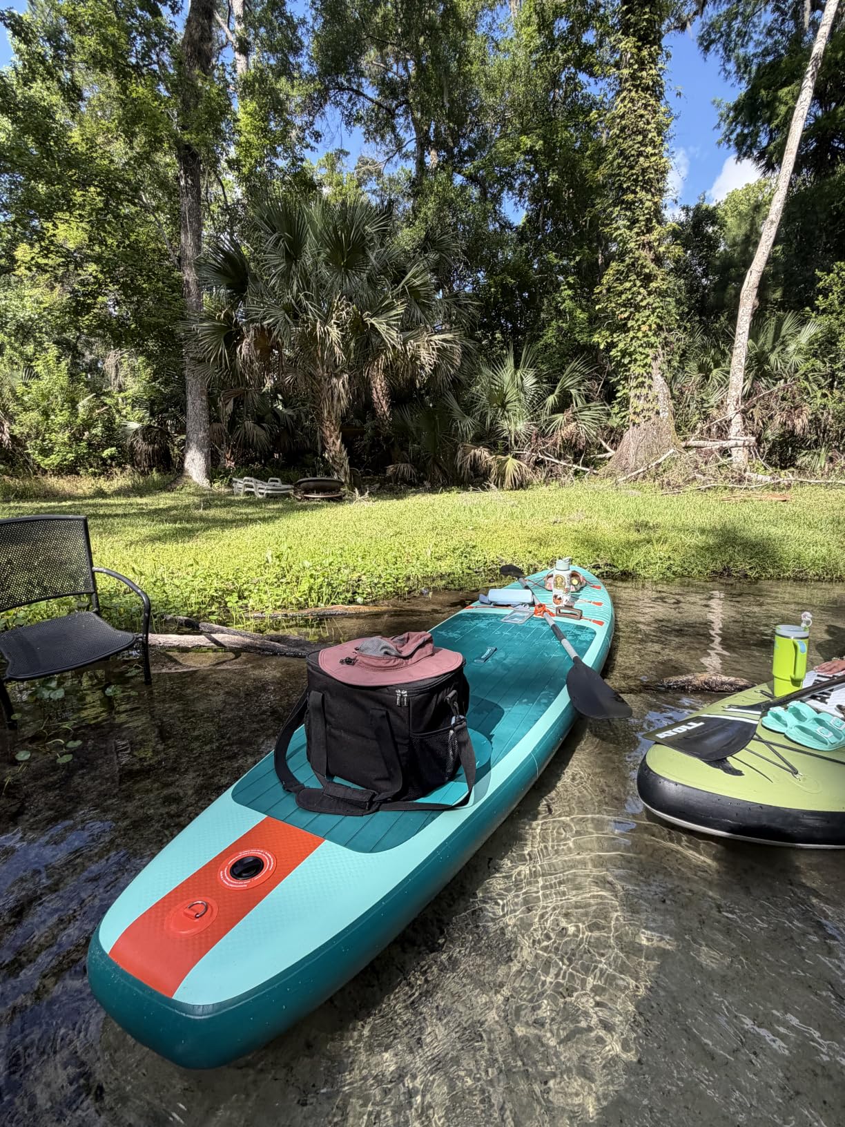 Retrospec Weekender inflatable paddle board floating on calm lake water