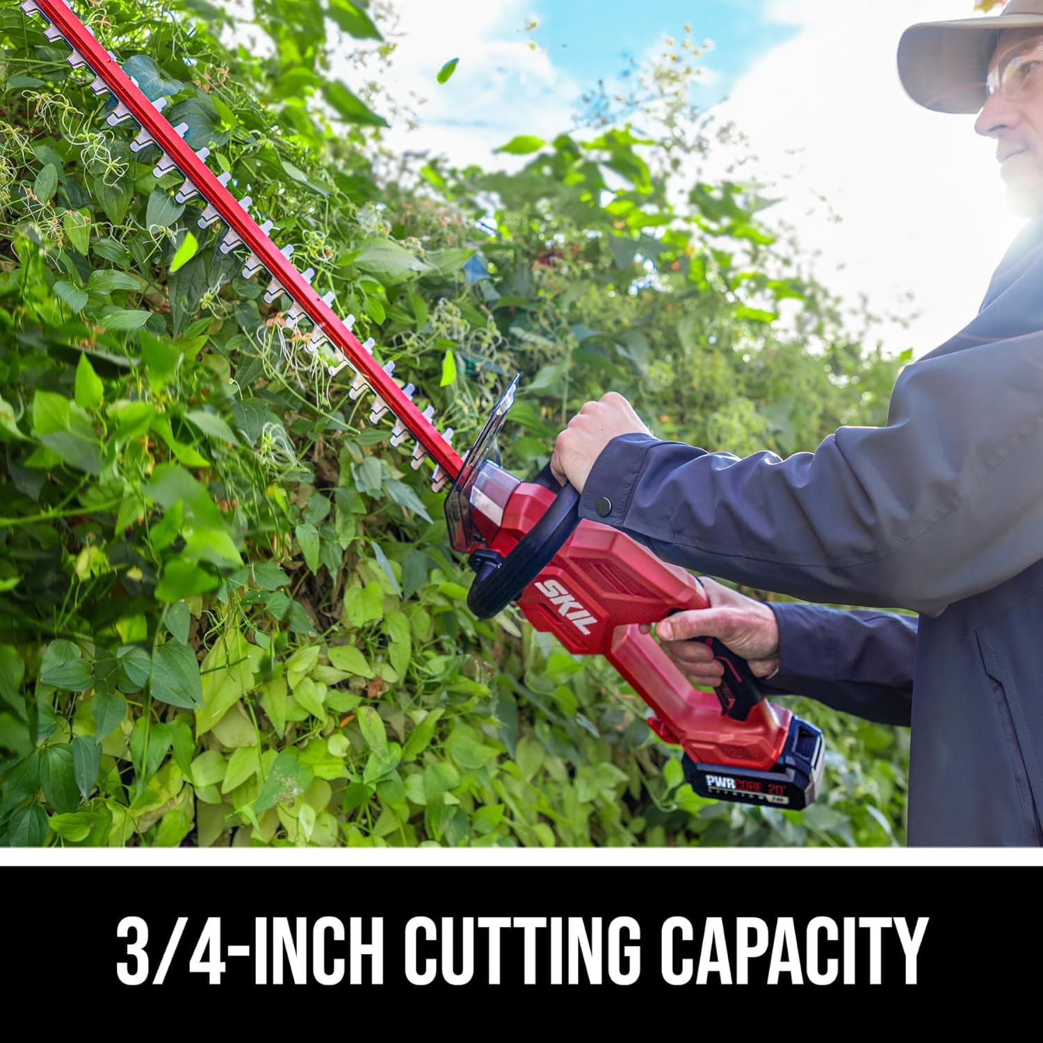 A person using the hedge trimmer to cut a hedge, demonstrating the 3/4-inch cutting capacity.