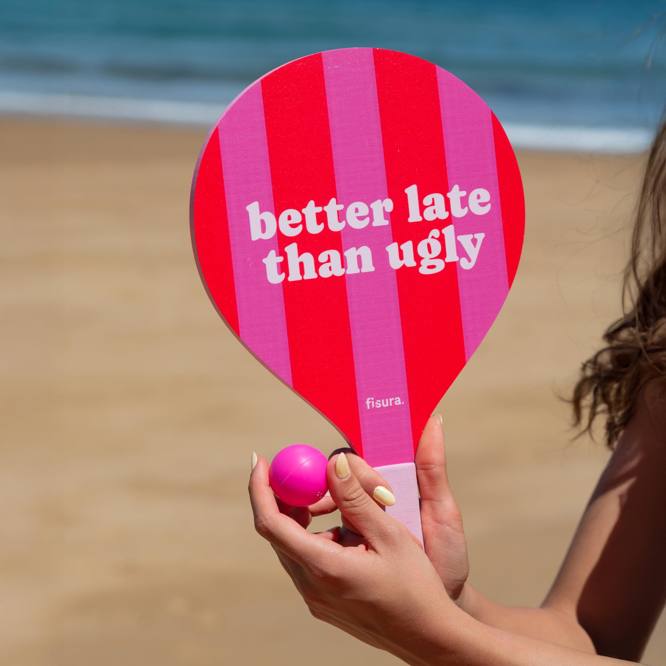 Fisura – Zestaw plażowych rakietek "better late than ugly”. Drewniane różowo-czerwone paletki z siateczkową torbą. Zabawne akcesoria na plażę. 2 piłki w zestawie.