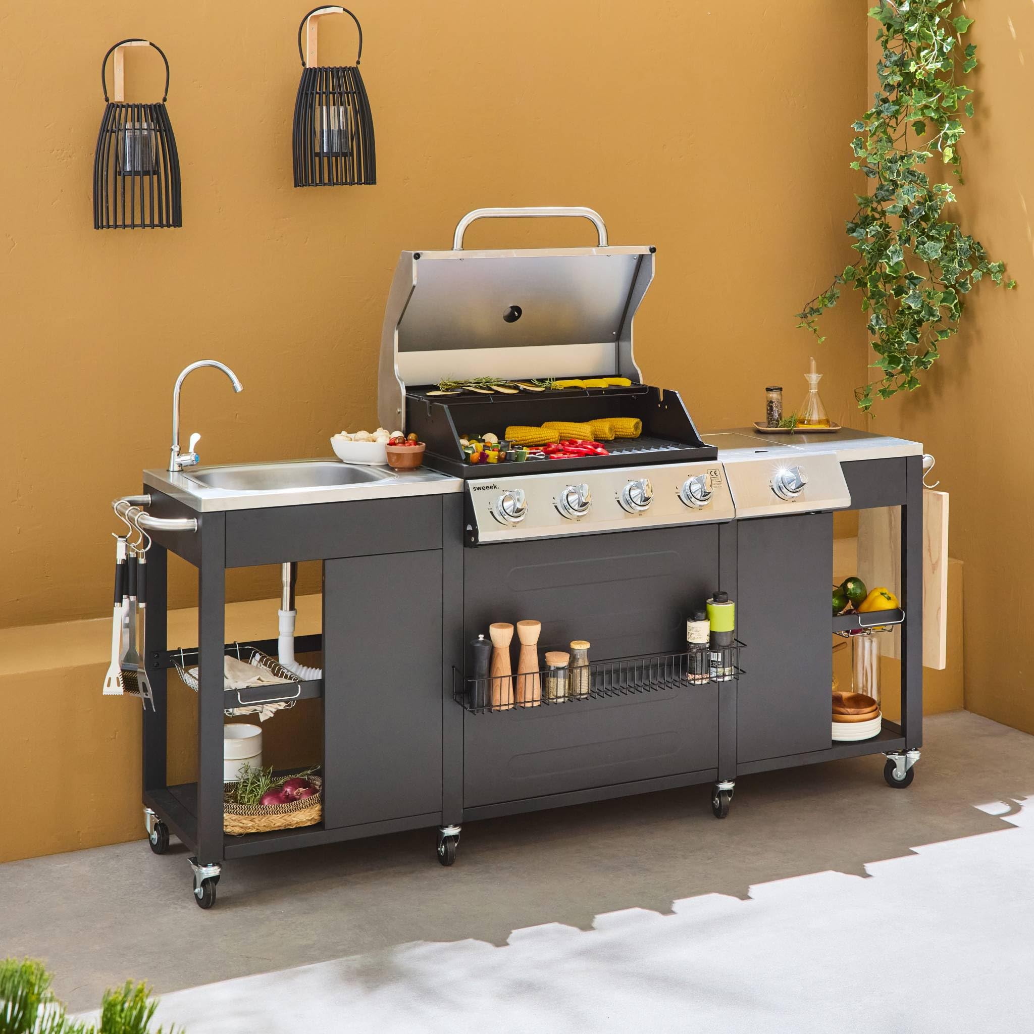 Alice's Garden - Barbecue. cuisine extérieure gaz - D'Artagnan - Barbecue 5 brûleurs dont 1 feu latéral. inox et noir. évier. planche à découper bois. ustensiles