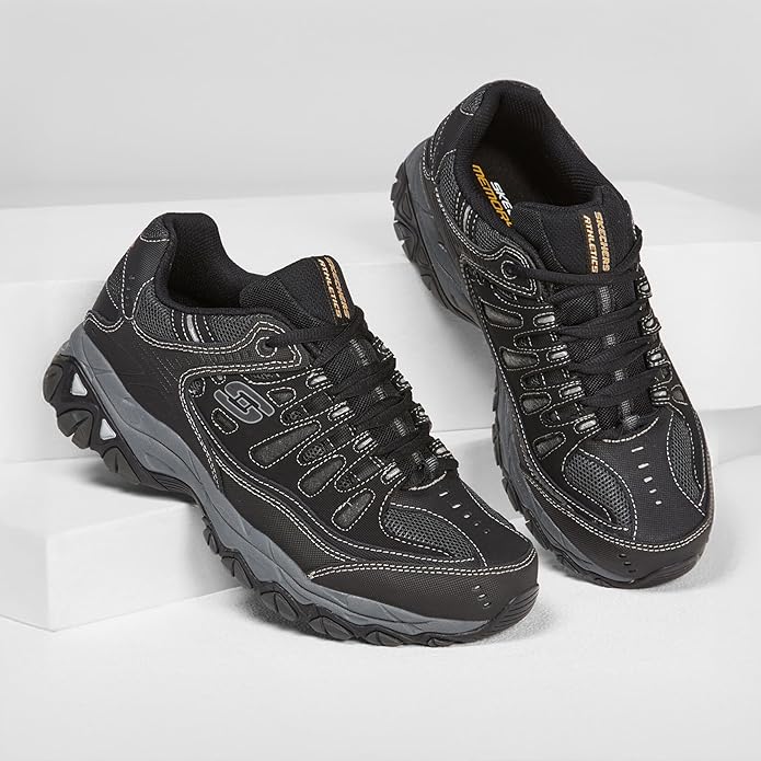 Pair of Skechers Men's Afterburn Memory-Foam Lace-up Sneakers in black with gray accents, angled three-quarter view showing both shoes on a white surface, highlighting lace-up closures, mesh panels, supportive overlays, rugged outsoles, and visible Memory Foam insole