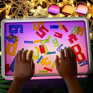 Child arranging translucent geometric shapes on a glowing light table
