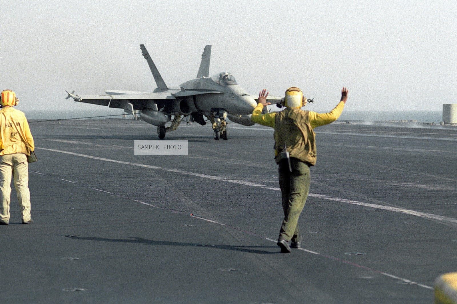 Photo A flight deck crew member signals to the pilot of an F/A-18C Hornet aircraft on the flight deck of the aircraft carrier USS Independence (CV-62). The carrier is underway in the gulf during Operation Southern Watch, a multinational effort establishing a no-fly zone for Iraqi aircraft south of the 32nd parallel in Iraq, 09/01/1992