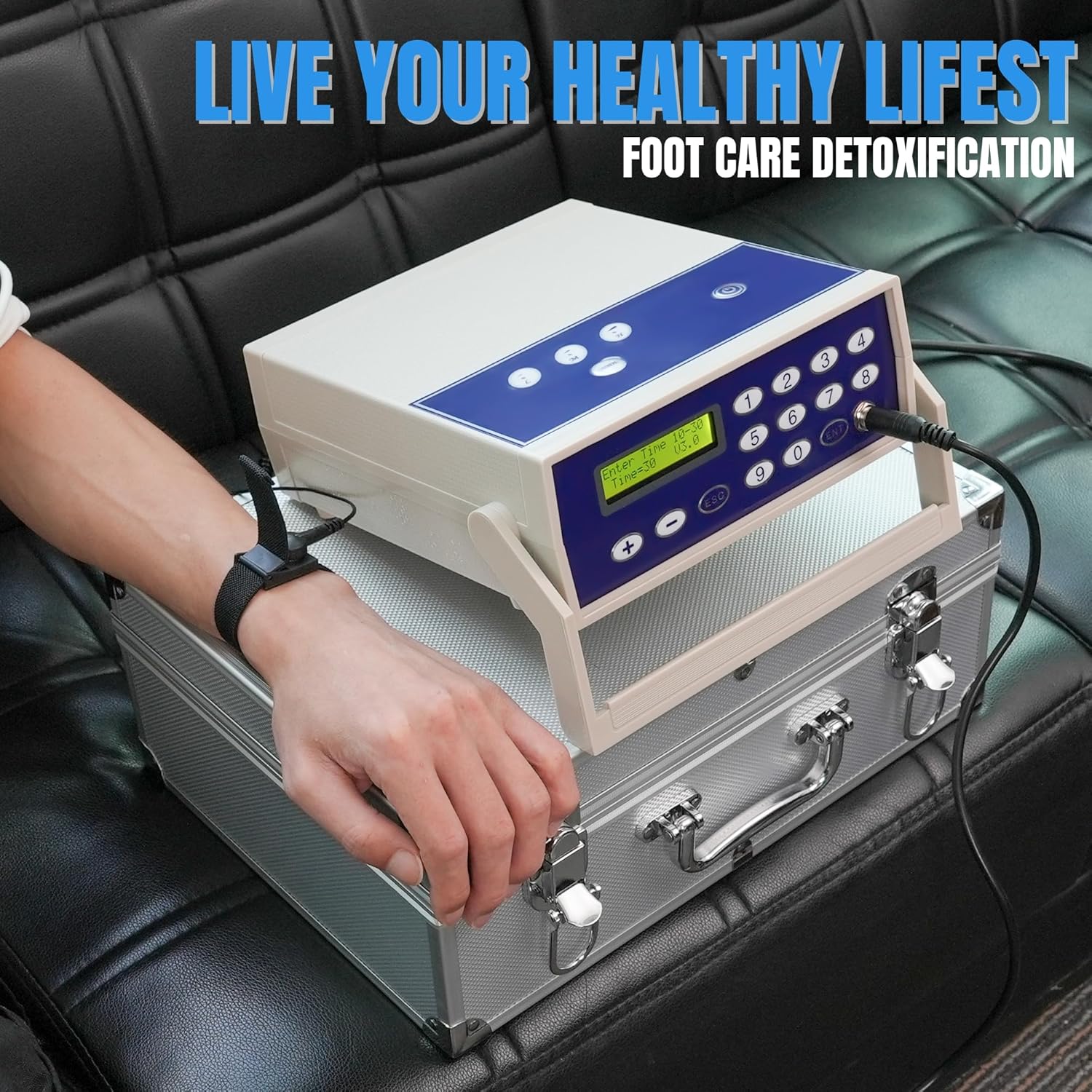 A person wearing the wrist strap and touching the control unit of the foot bath detox machine.