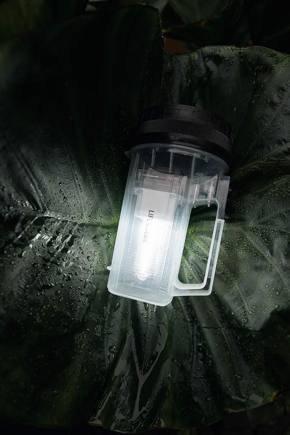 Life Gear flashlight placed on a wet leaf, demonstrating its water-resistant feature.