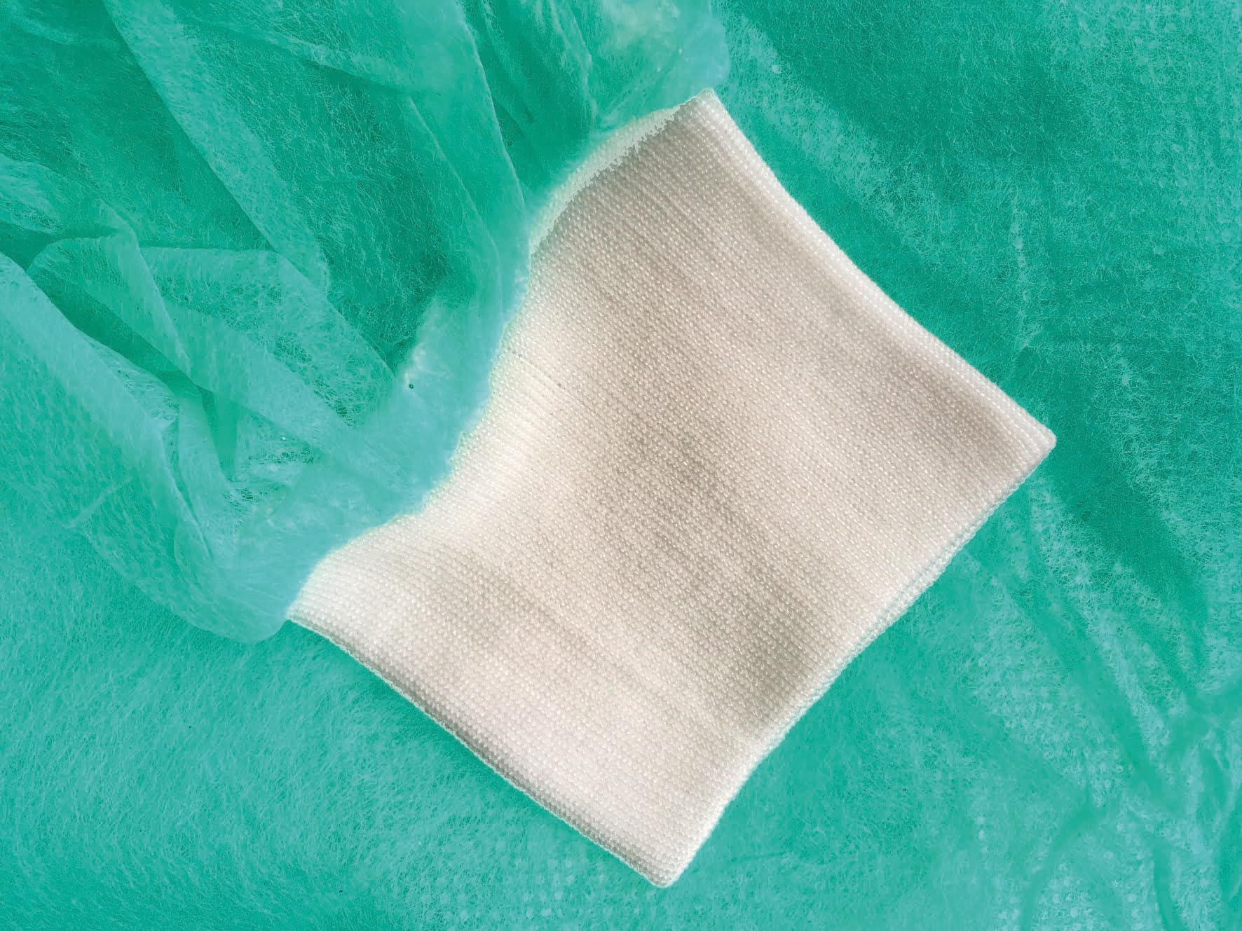 TIGA-MED Einwegkittel – 100 Stück - Vlies Schutzkittel mit Trikotbündchen, 130 × 155 cm, grün – MRSA geeignet – Besucherkittel für Klinik, Praxis, Pflege & Labor