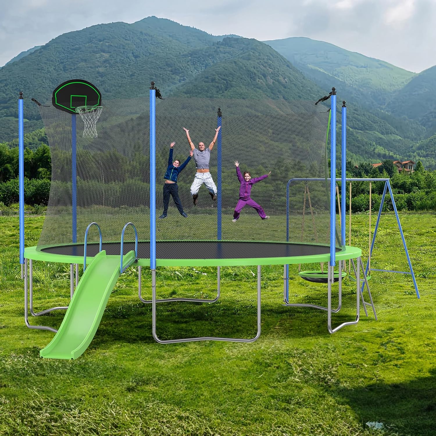 A large 14FT trampoline with a safety net, slide, and swing set in a green outdoor setting, with mountains in the background.