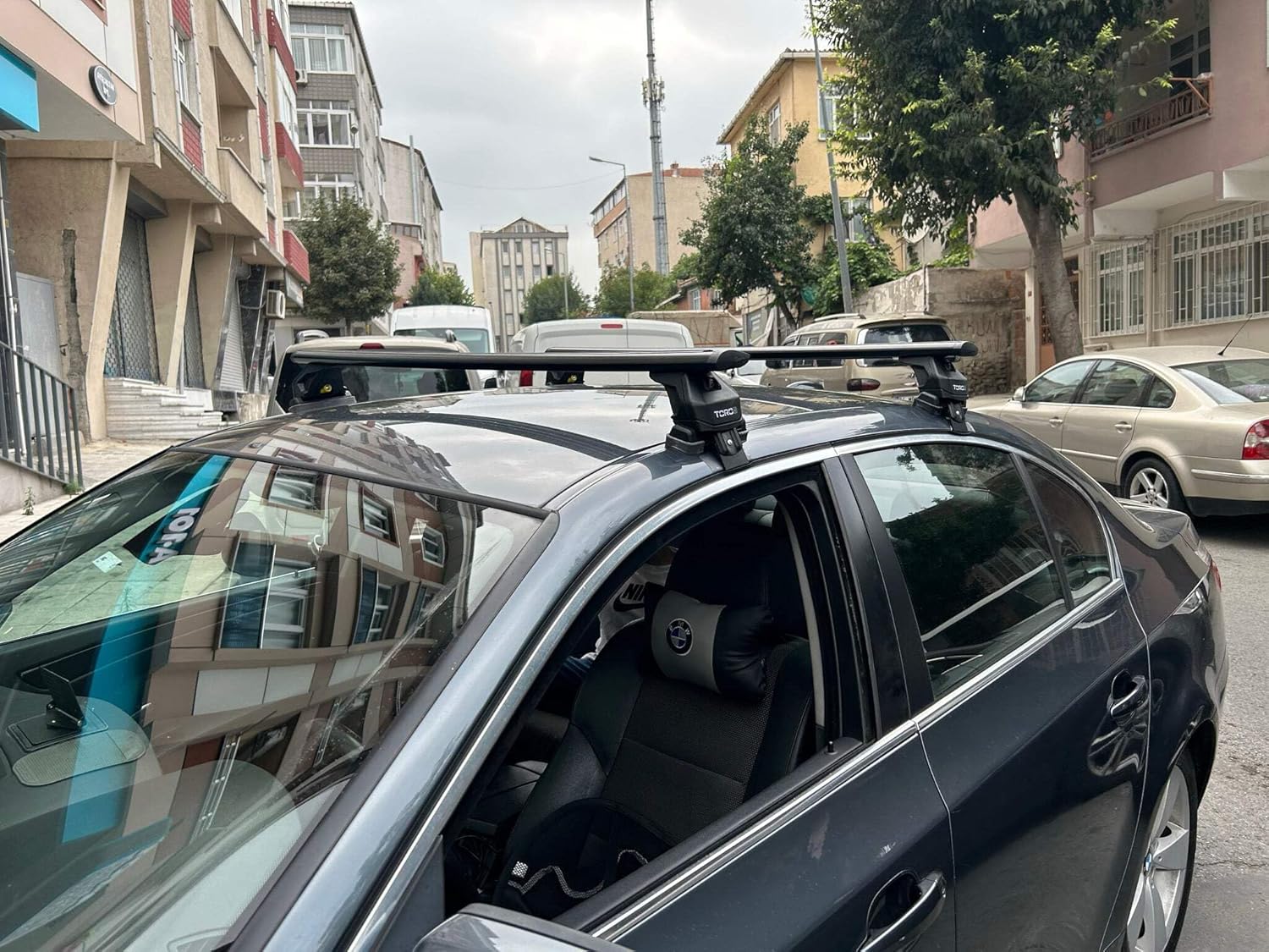 Side view of a car with the auto paw roof rack system installed, showing both cross bars.
