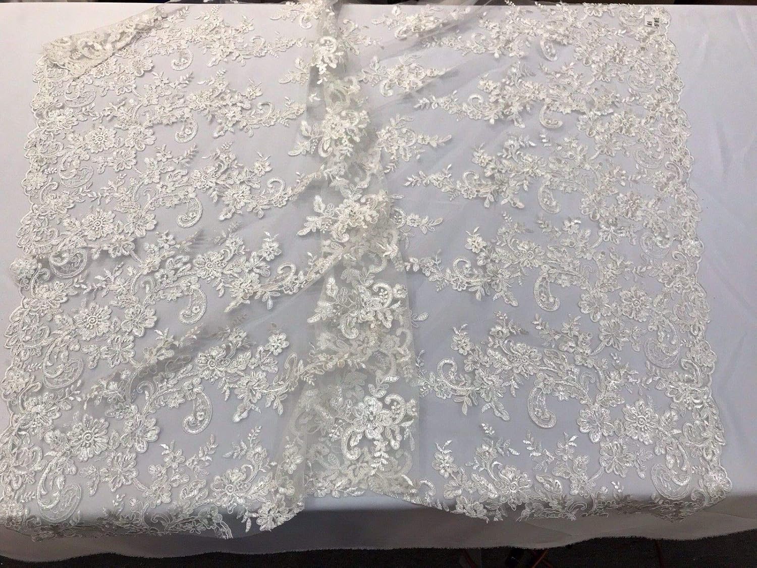 IVORY FLORAL DESIGN EMBROIDER WITH SEQUINS-CORDED LACE-SOLD BY THE YARD.