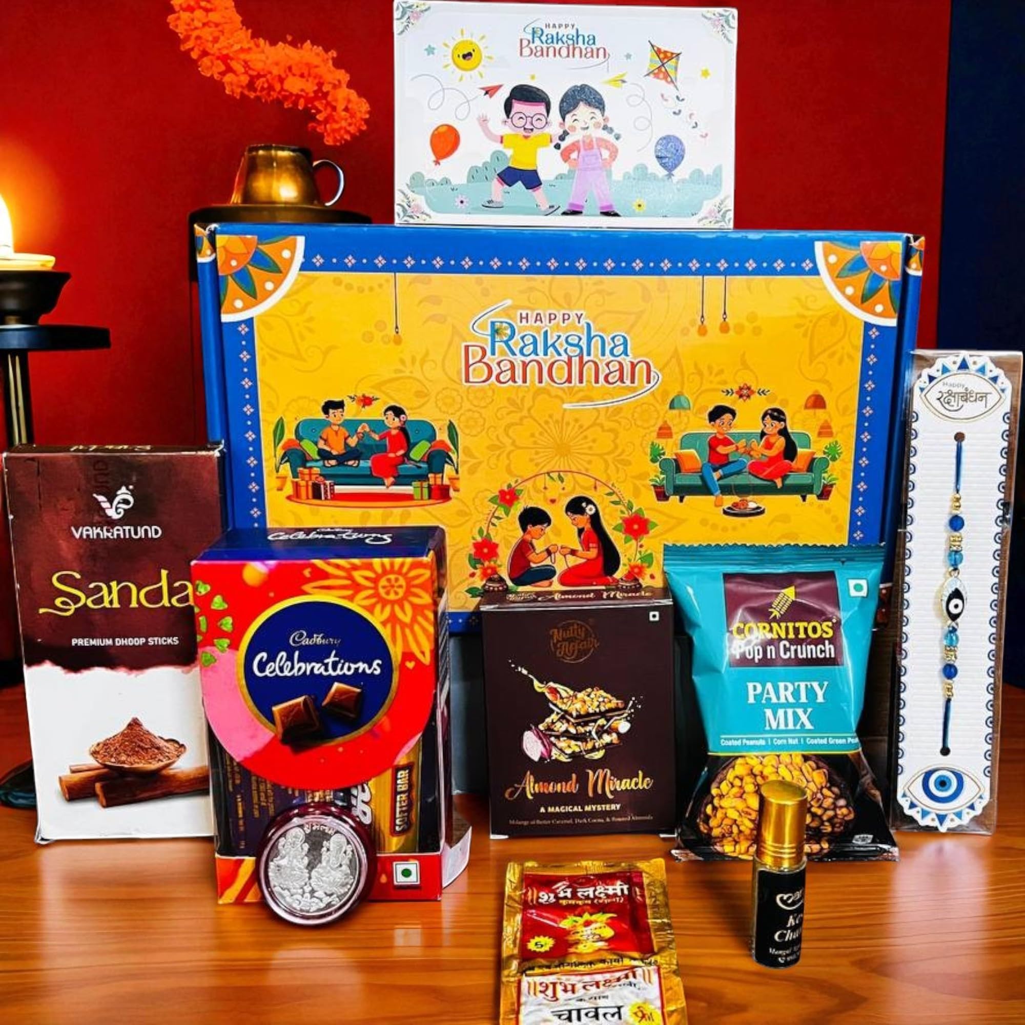 nuttygritty rakhi gift combo box for brother bhaiya & bhabhi-9 inclusions + evil eye rakhi nazar kavach|chocolate,millet namkeen,almond bar,incense sticks & stand,perfume,coin,card,roli chawall