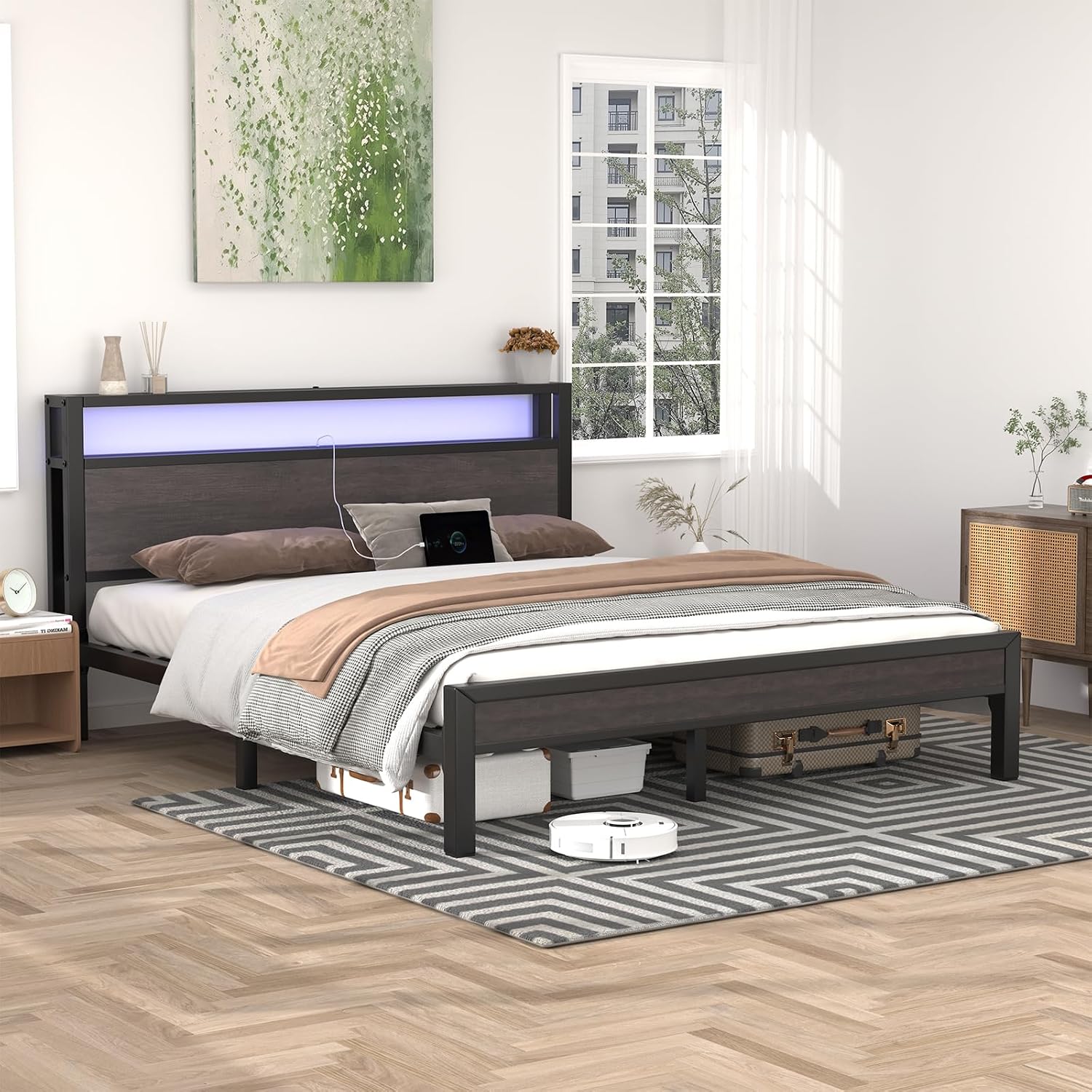 Bed frame showing under-bed storage space with boxes and a robot vacuum.