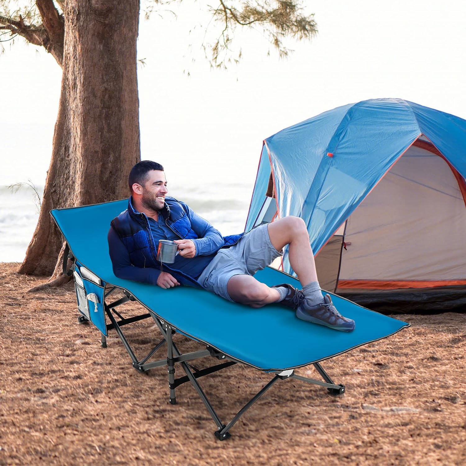 Man relaxing on GYMAX Camping Cot outdoors