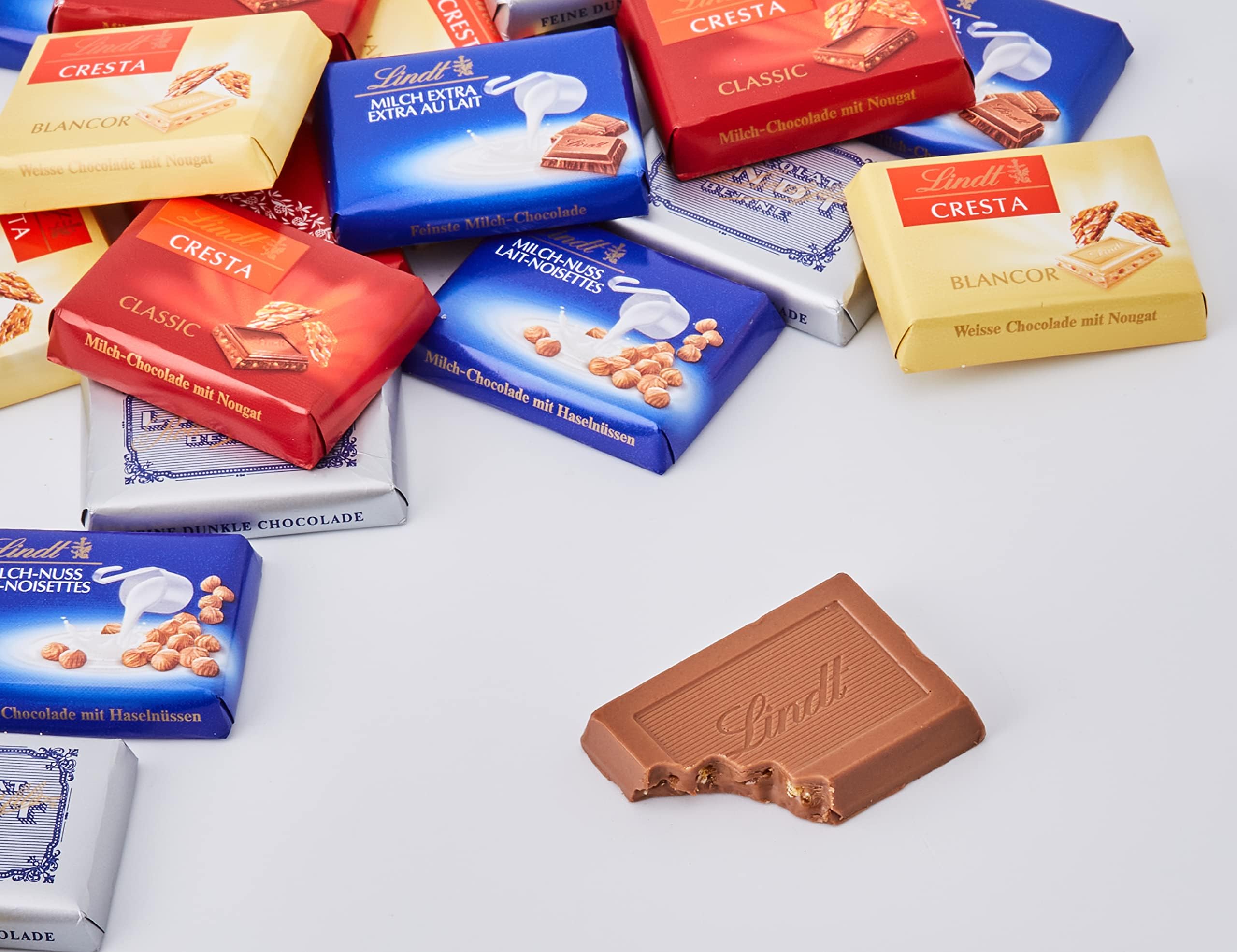 LINDT Napolitanas Suizas, contiene un surtido de minitabletas de chocolate envueltas individualmente, chocolate con leche, de chocolate blanco,chocolate negro,chocolate con avellanas, aprox76uds, 500g
