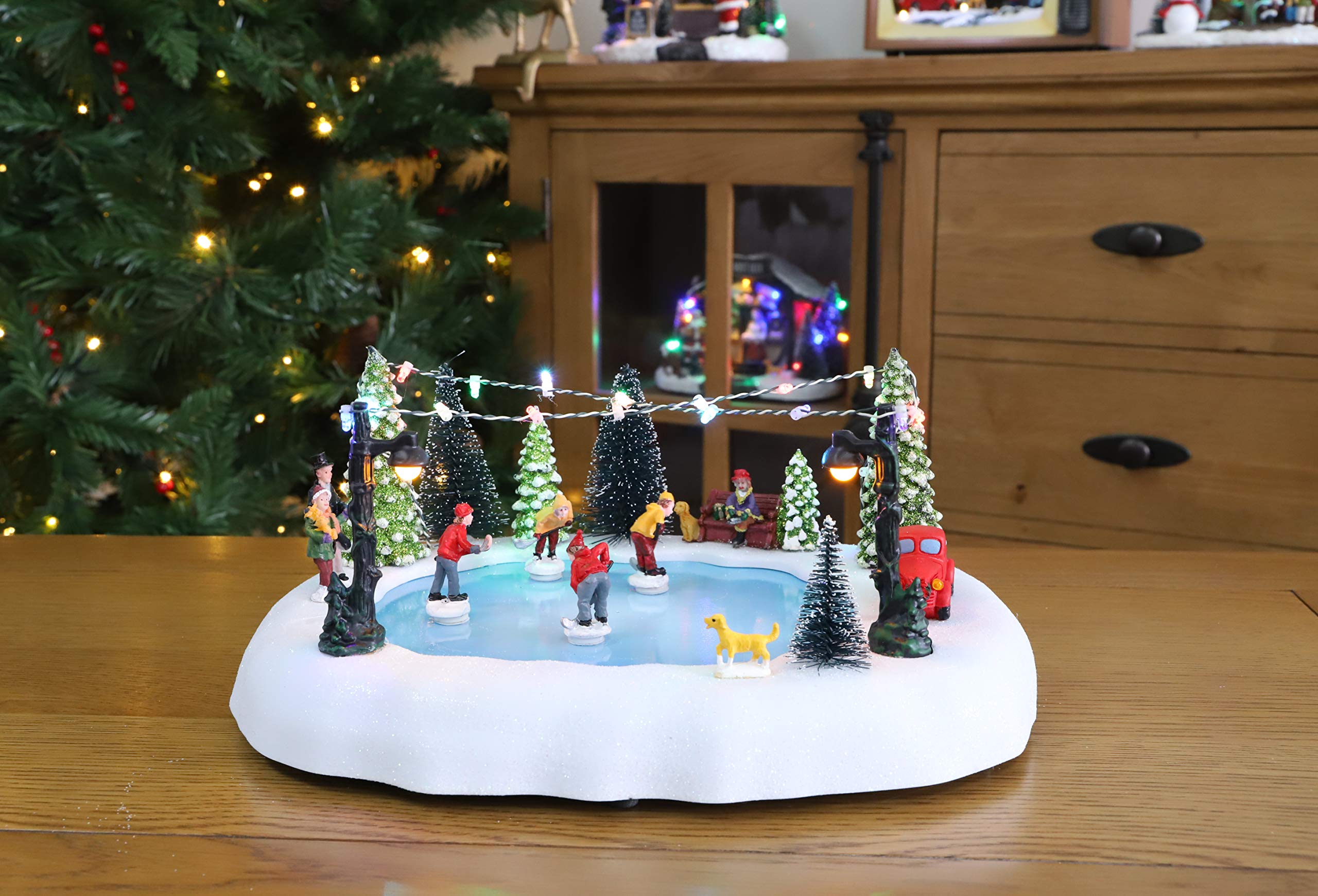 Christmas Concepts® Scène de village à patinoire animée à LED fonctionnant à piles, avec 8 mélodies de Noël - 30 cm