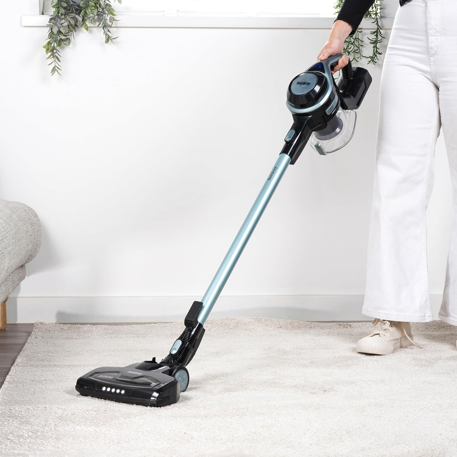 Person using the Beldray Airgility Cordless Vacuum Cleaner on a carpeted floor, demonstrating its upright use.