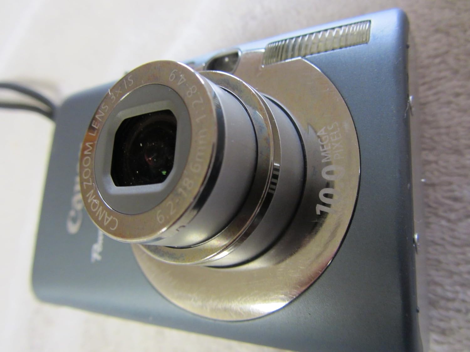 Наклонный фронт view of Canon PowerShot SD1200IS with lens extended