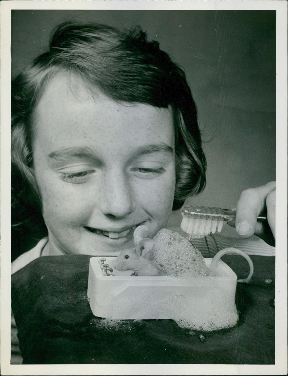 Vintage photo of A vintage photo of a boy washing a rat toy