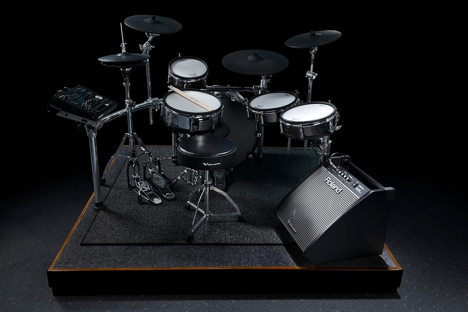 Roland PM-200 monitor positioned next to an electronic drum set