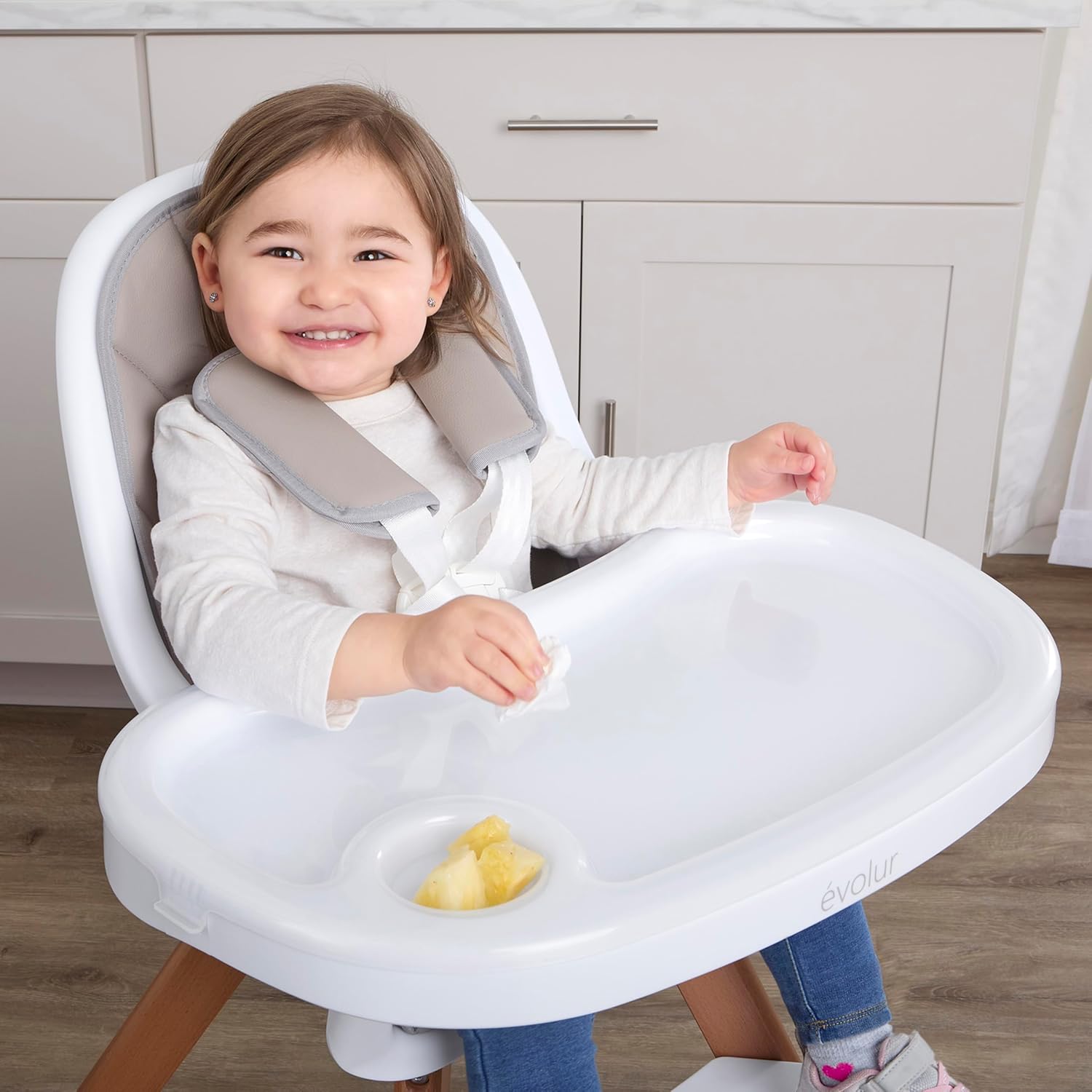 Diagram highlighting key features of the Evolur Zoodle high chair: sleek design, 5-point harness, removable tray, washable seat cover, two footrests, beechwood legs, and anti-skid pads.