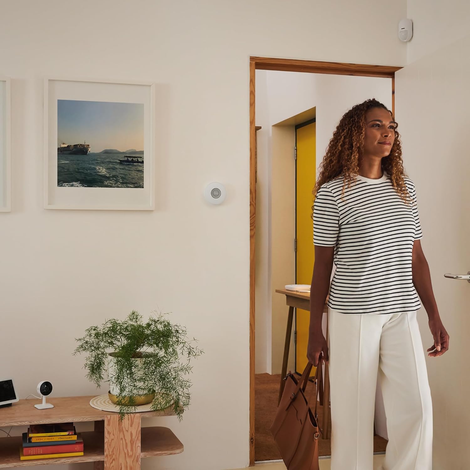 Person holding a smartphone displaying the Yale Home app interface