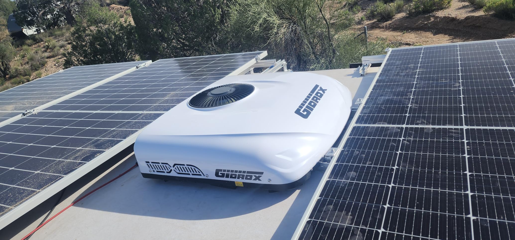 Gidrox 12V DC RV air conditioner installed between rooftop solar panels