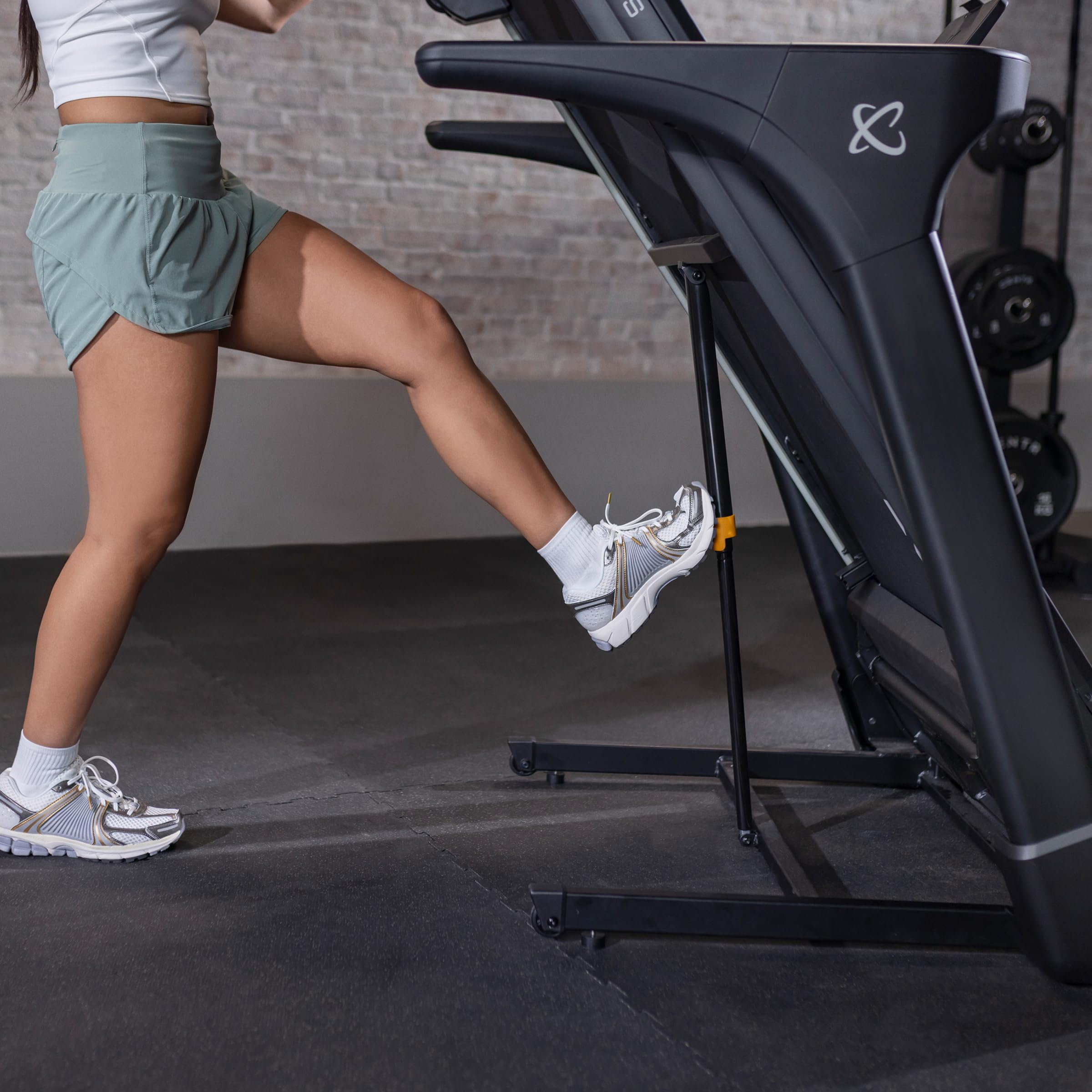 Person unfolding the Inspire Series T4 Treadmill