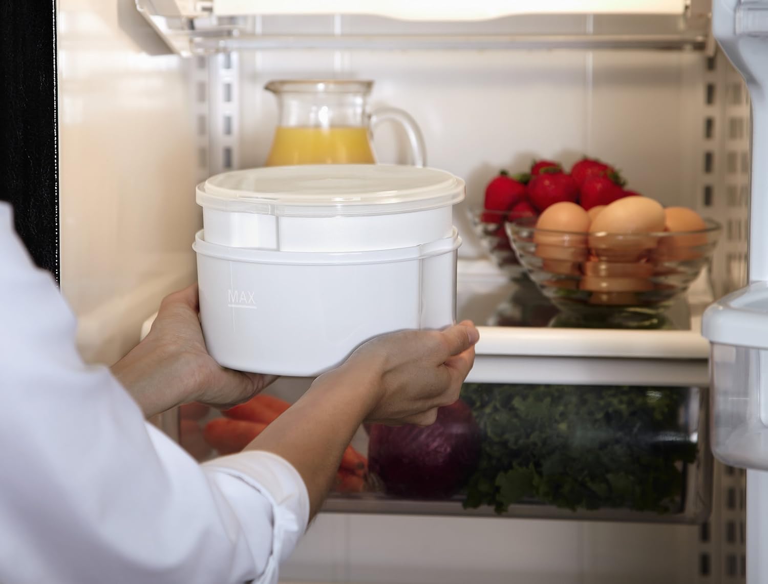 Person placing large container of yogurt into fridge