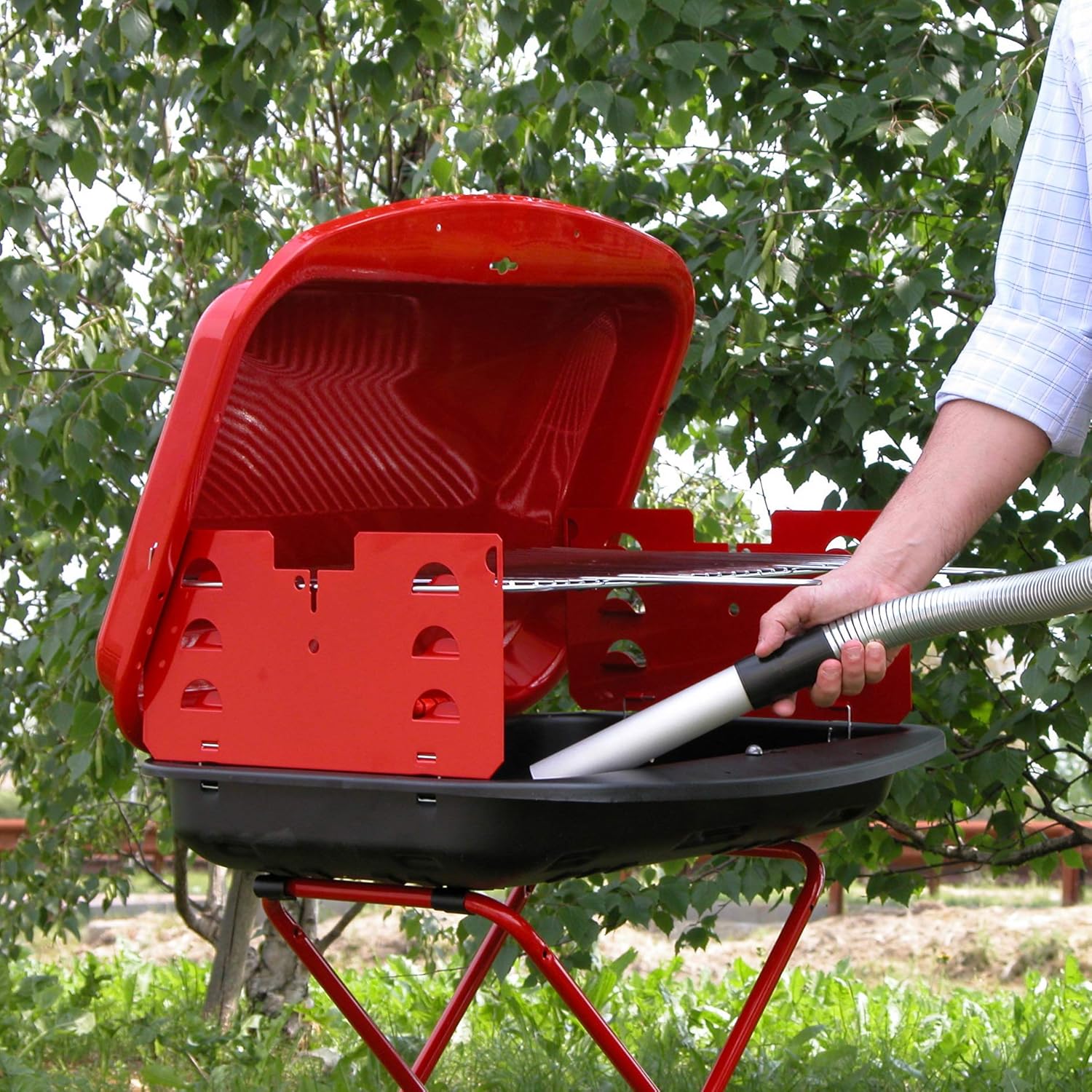 Person using Lavor Ashley 901 Ash Vacuum Cleaner to clean a grill